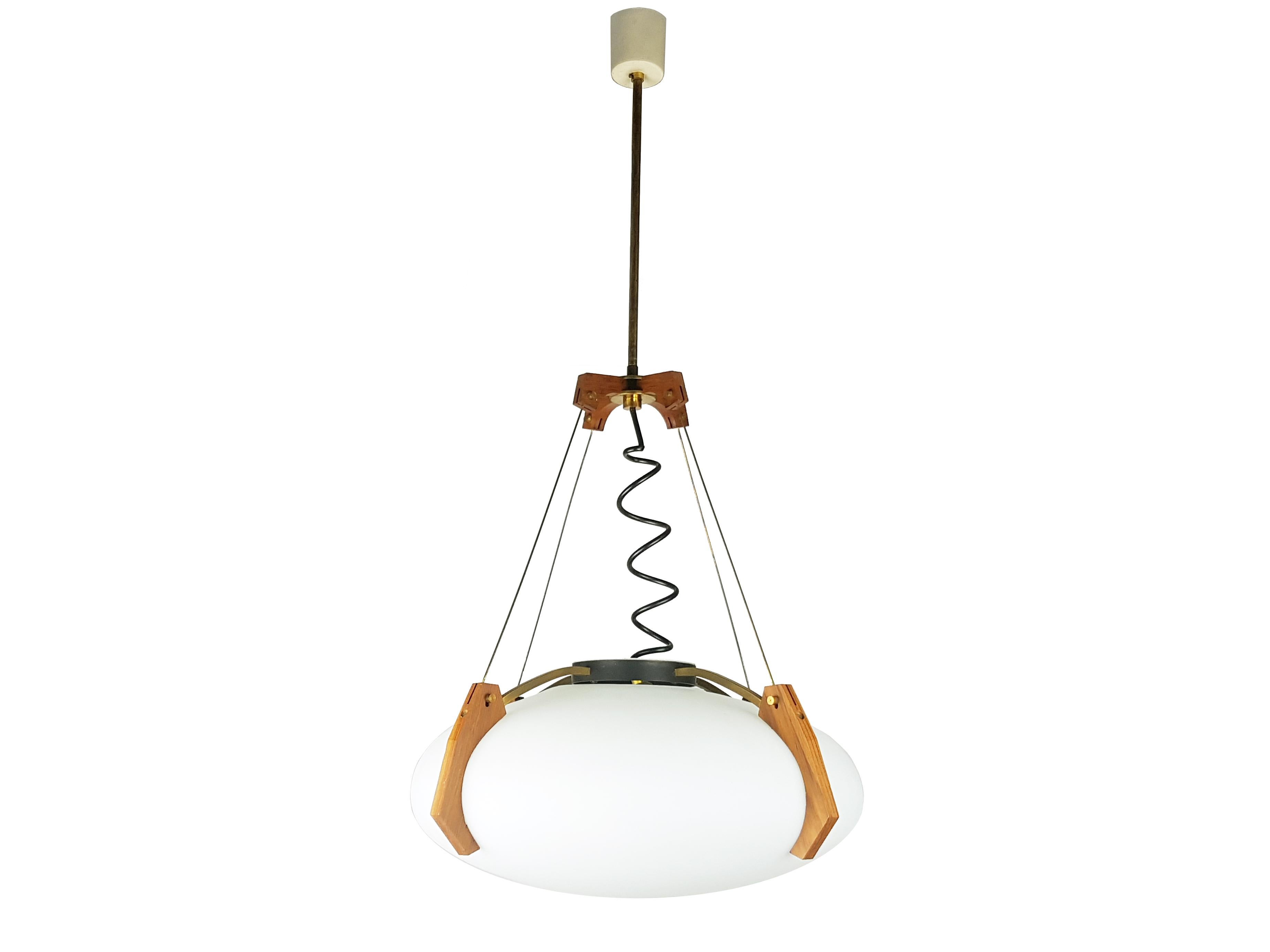 This beautiful and rare pendant was produced in Italy in the late 1950s. Its design and its high quality resembles the contemporary Stilnovo production. The lamp is made from a sandblasted opaline glass shade supported by 4 shaped teak holders with