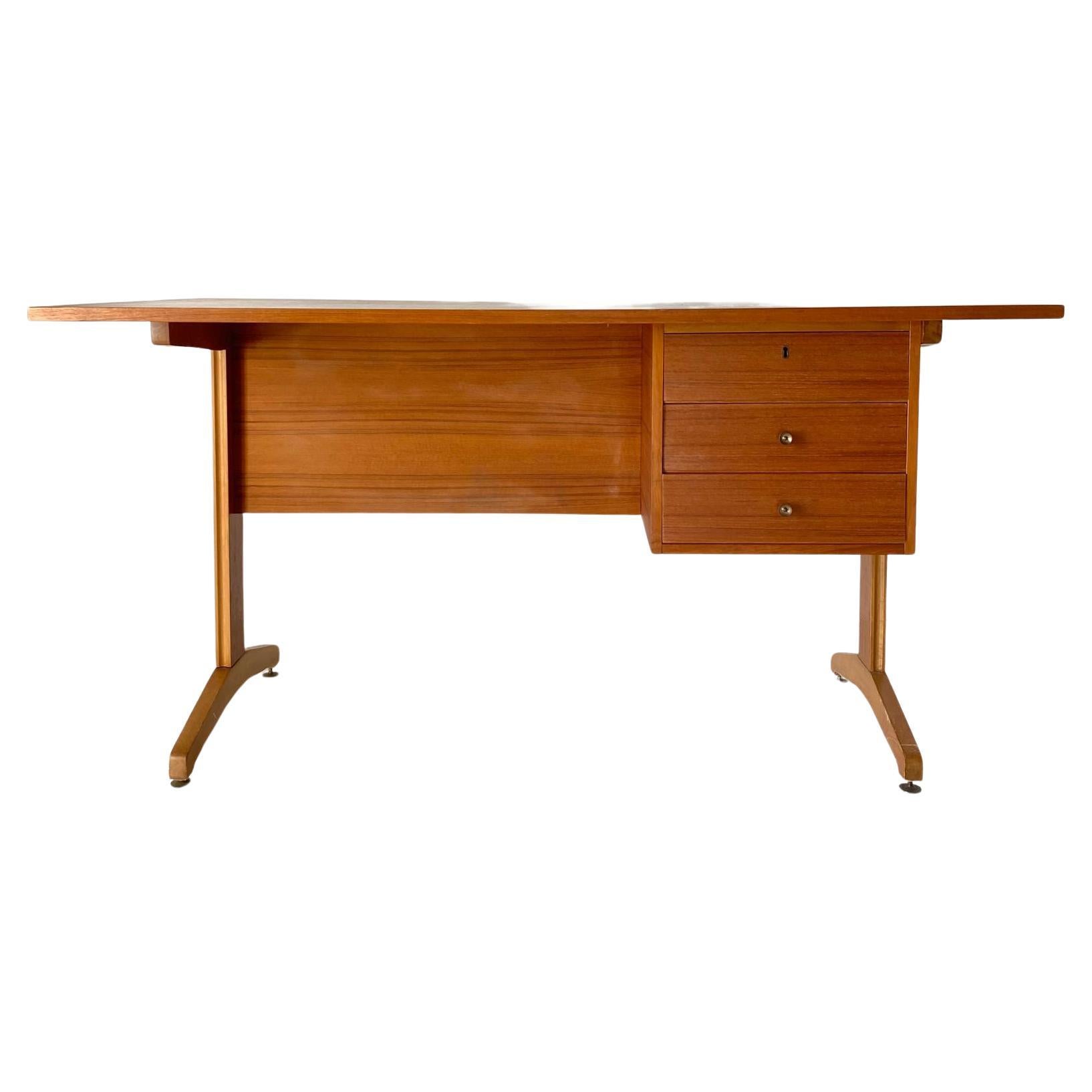 Vintage desk, Italy 1960s in the style of Gianfranco Frattini.
A beautiful italian desk with teak wood top and structure and cherry wood feet. 

Very stylish piece of design from the 1960s with side drawers underneath the top. Curved cherry wood