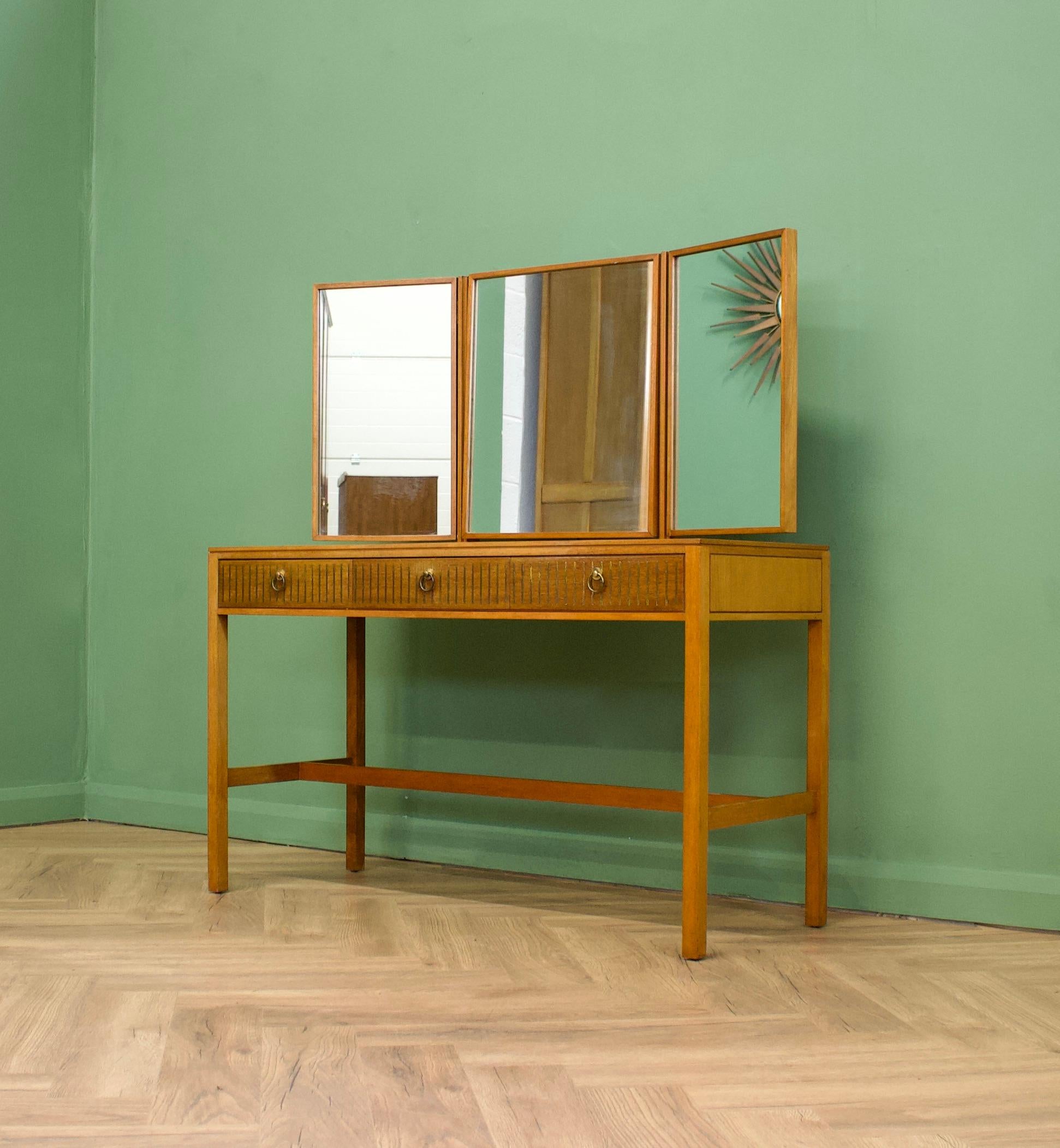 A teak & mahogany dressing table from Loughborough Furniture - retailed through Heals during the 1950s -  designed by Neville Ward and Frank Austin
This piece stands on slim legs and features three drawers - To them is unusual brass inlay details