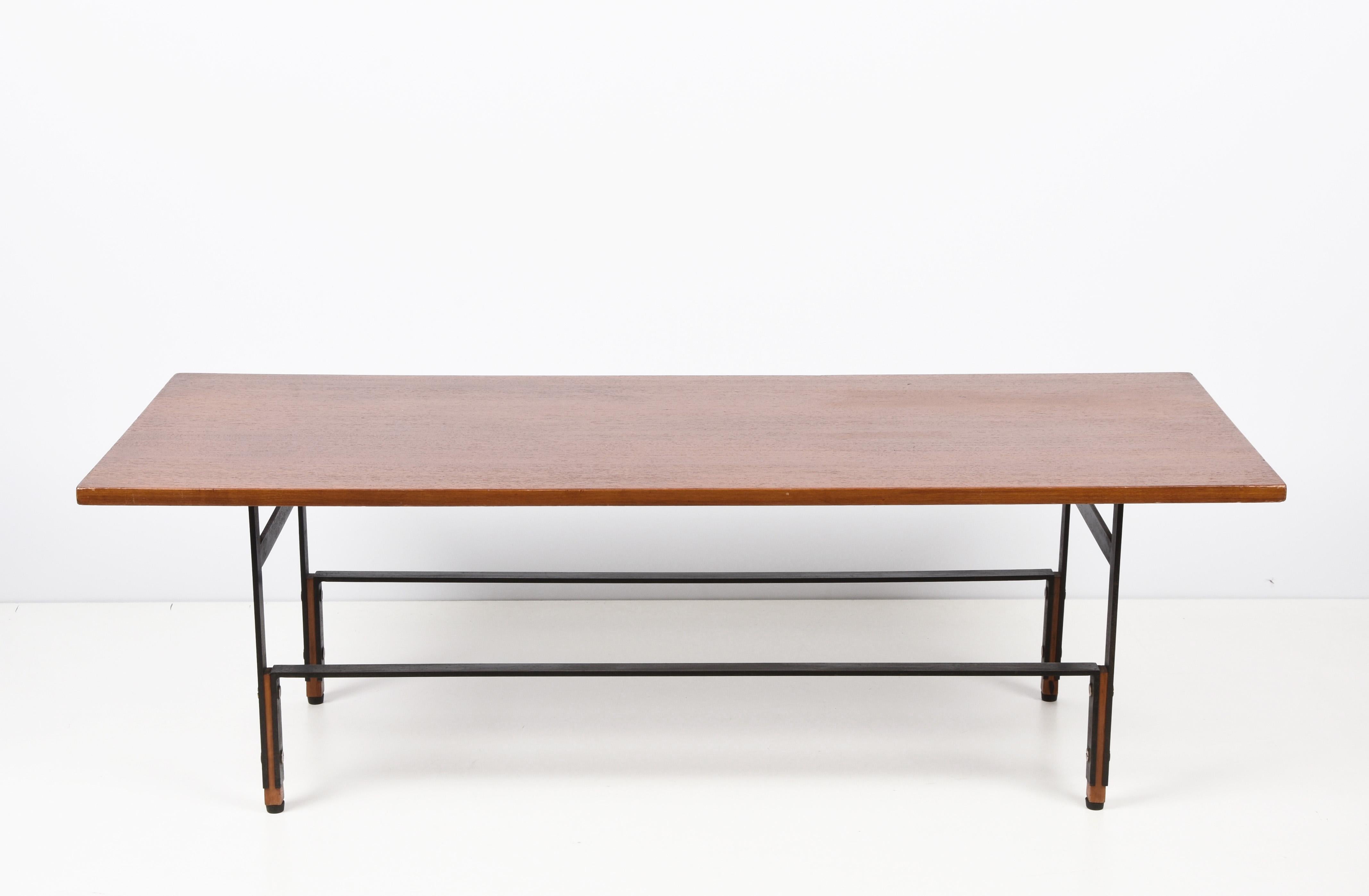 Spectacular coffee table in teak, black enameled iron and brass. This wonderful object was produced in Italy in the 1960s.

Everything in this article is classy: the materials, with a brown teak top and a black enameled metal structure; the lines,