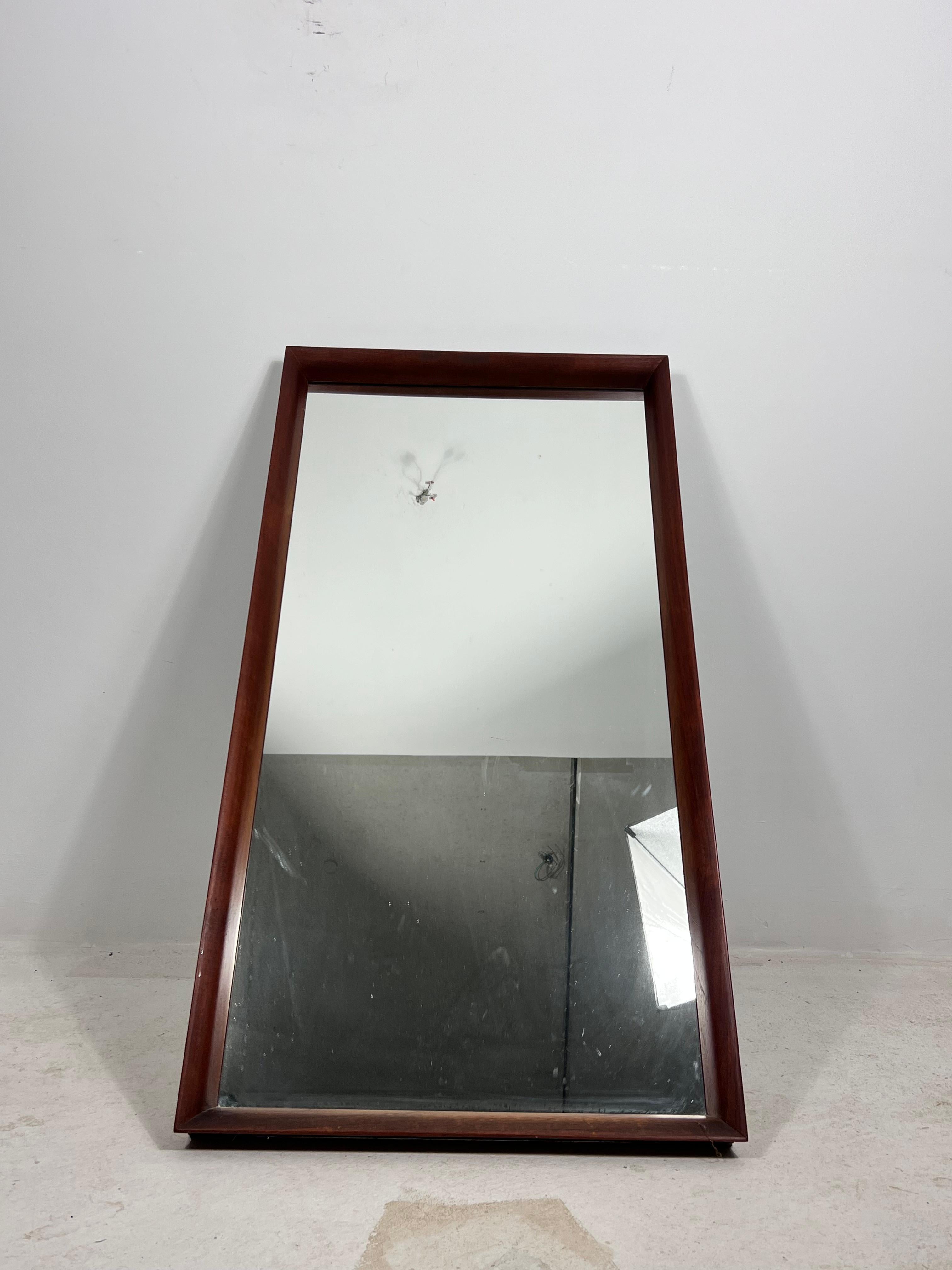 This elegant midcentury mirror was crafted in Germany during the 1960s. It features a solid teak frame with a warm, natural finish that highlights the wood’s fine grain and depth of tone. The subtly tapered trapezoid shape gives the piece a