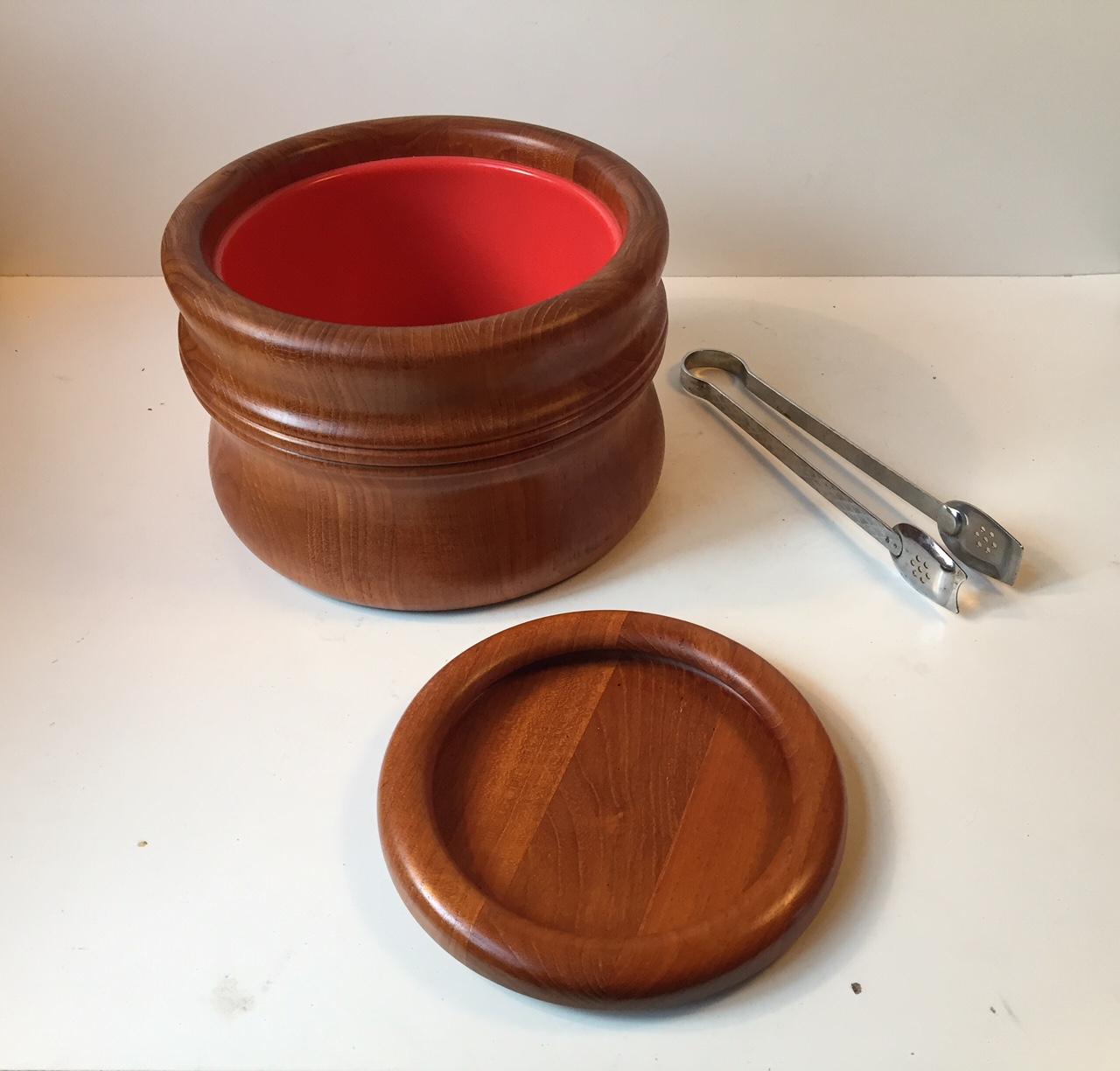 1960s teak ice bucket designed by Richard Nissen for his own company Nissen in Denmark during the 1960s. Its made from organically shaped teak, its lined with orange plastic and the lid doubles as a snack bowl. Its stamped by the maker to the bottom.