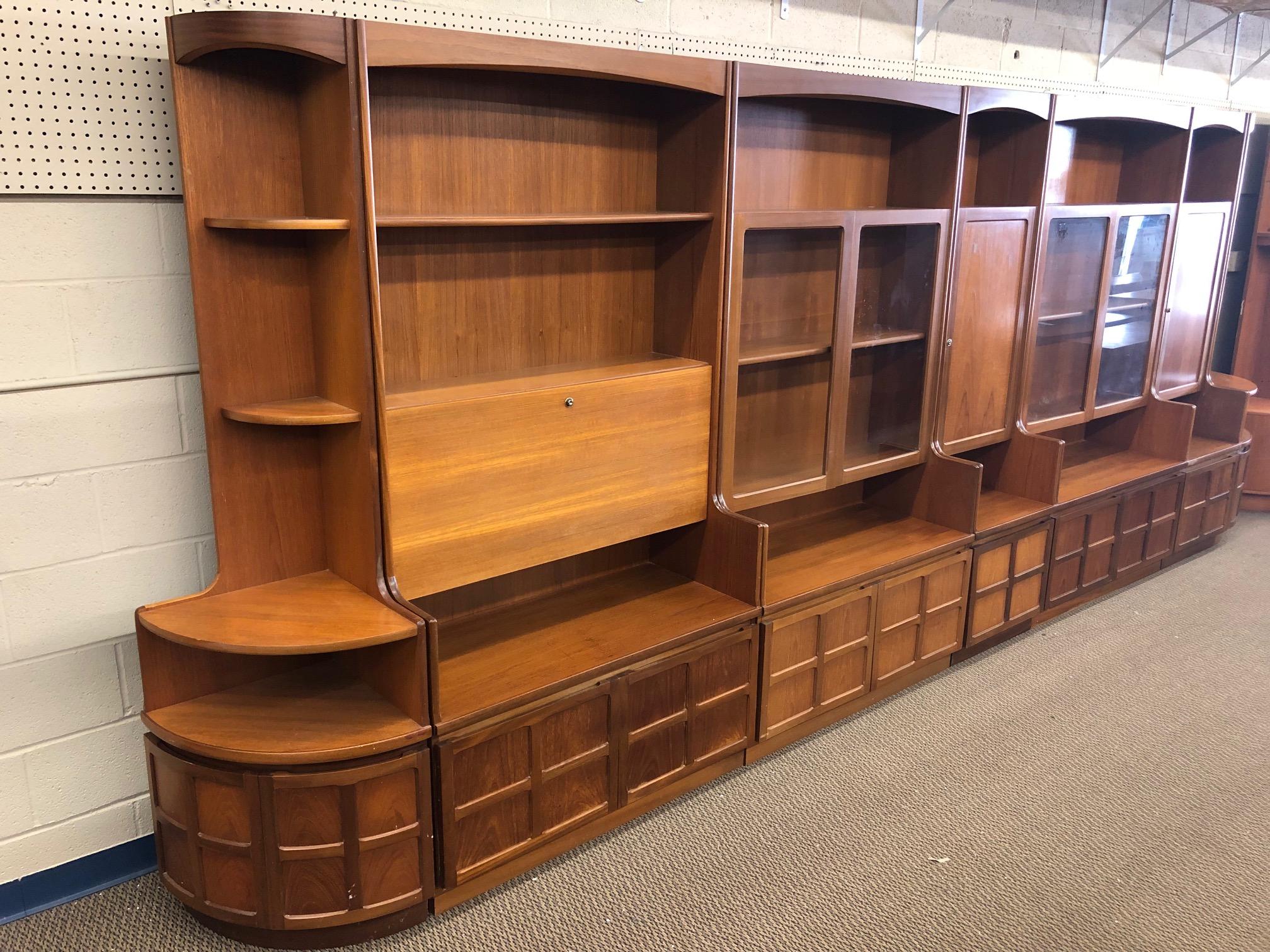 Fantastic teak wall unit made by Nathan Furniture. Made in England. Can be arranged anyway you like. The photo shows just one possible set up.

Features 2 smaller corner units and 3 wide main units and 2 narrow main units. One main unit has a drop