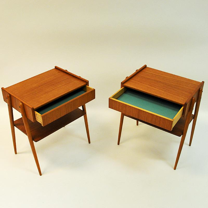 Nice and elegant pair of vintage teak bedside tables with drawers and sligthly outwards tilted legs. Produced by AB Carlström & Co Möbelfabrik in the 1950s. Sweden.
These midcentury night tables has rounded legs and underneath a shelf for newspaper,