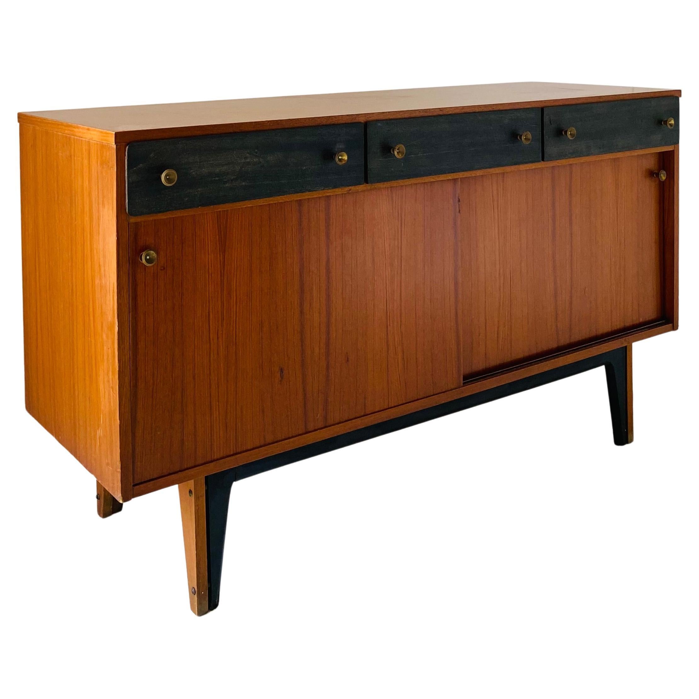 A 1950s vintage sideboard. Teakwood structure with three black painted drawres and sliding cases. Brass pommels. Restored as follows: Wood has been polished. Drawers perfectly openable.  Manufactured in Italy. In very good conditions with some signs