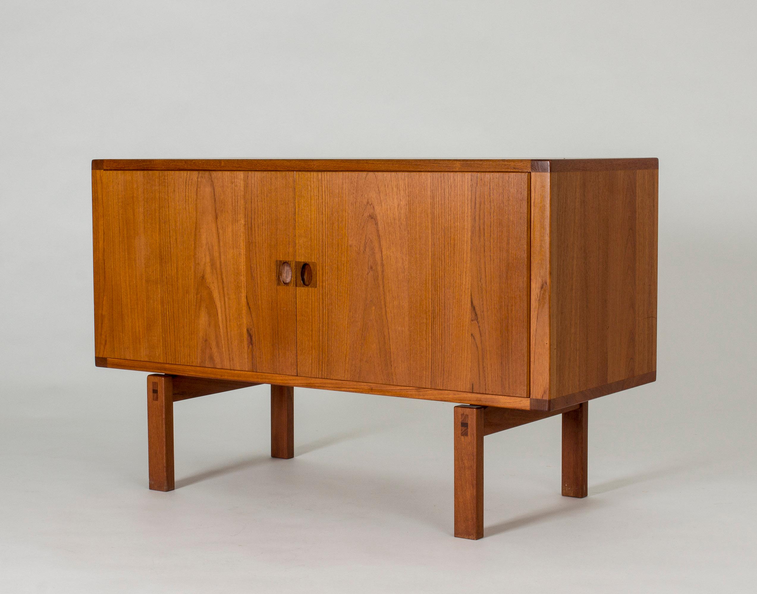 Small teak sideboard by Lennart Bender with decorative carved out handles and inlays at the tops of the legs. Veneer on the back.