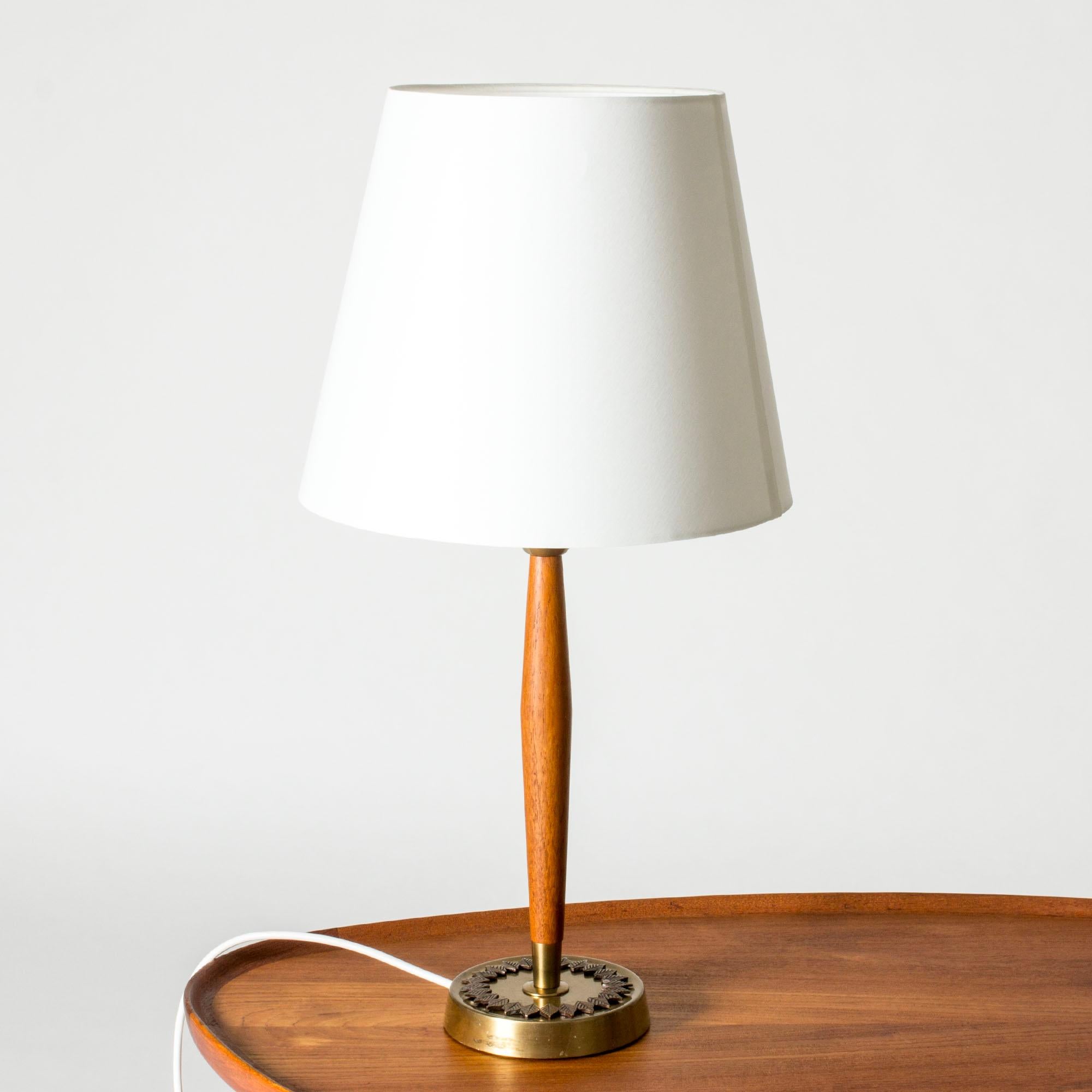 Elégante lampe de table d'ASEA, fabriquée en laiton et en teck. Base décorée d'un beau cercle de feuilles stylisées.