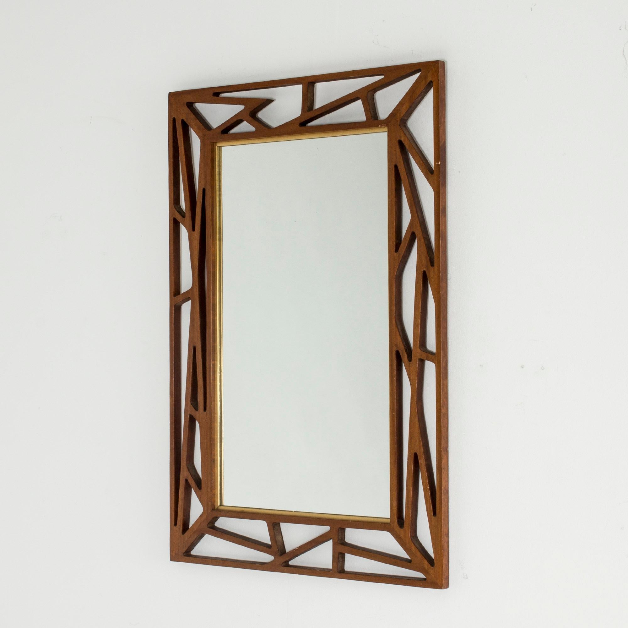 Stunning mirror from Eden Spegel, with an ornate teak frame, designed in a cutout, graphic pattern. Inner golden frame. Bold and tantalizing.