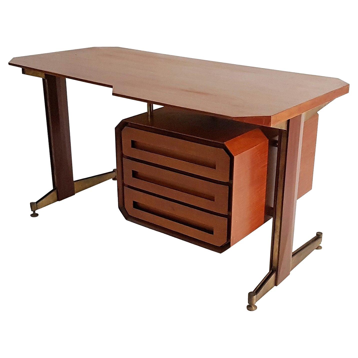 Beautifully designed Italian writing desk in teak and brushed brass. With a very distinct design this desks every wood surface has been given specific angles such as the tabletop, the unit with drawers as well as the side of the legs. The angles as