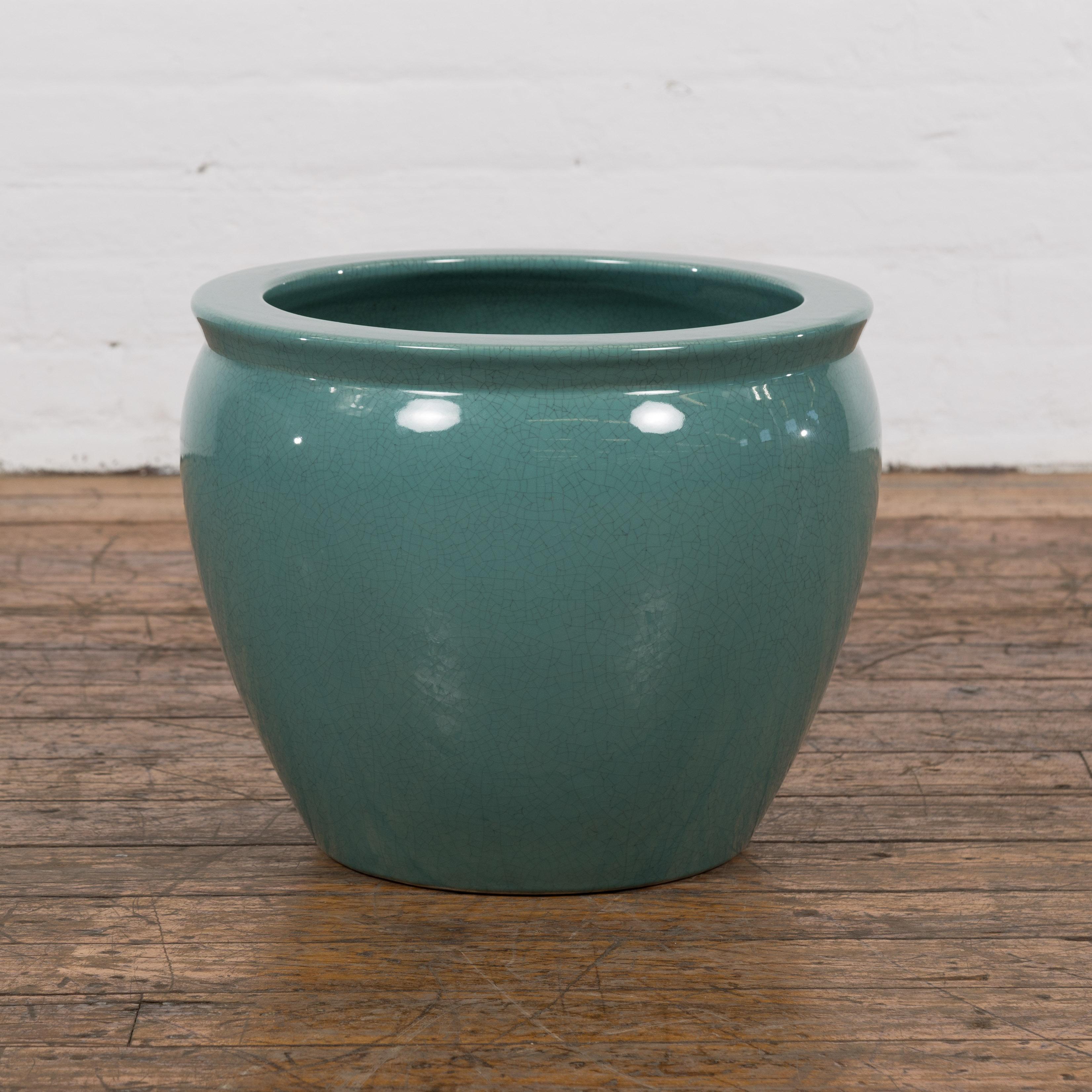 A Midcentury teal glazed ceramic garden planter with circular mouth and tapering lines. Hailing from the golden age of design, this Midcentury ceramic garden planter is a brilliant blend of form and functionality. Coated in a vibrant teal glaze, the