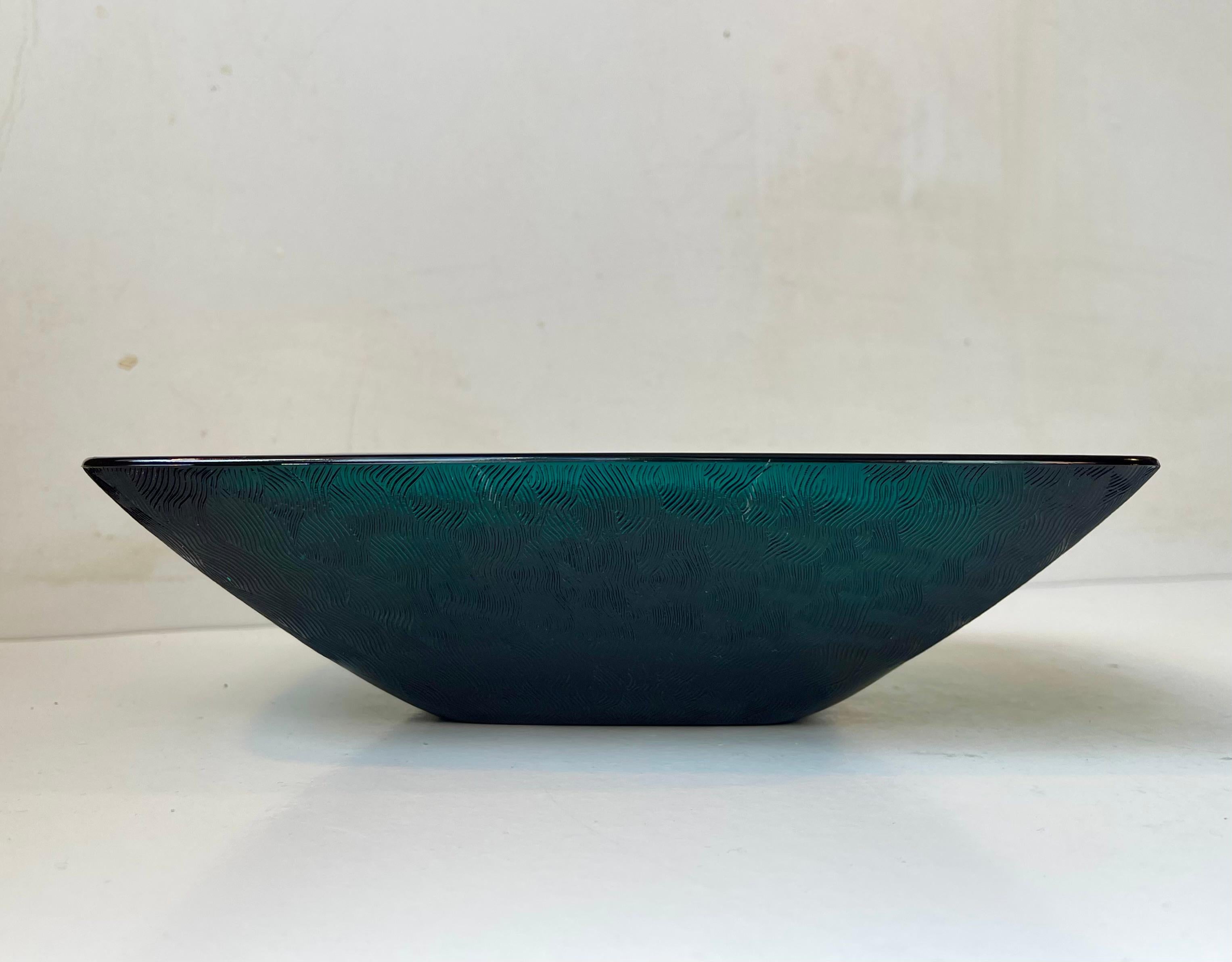 Une très rare coupe rectangulaire en verre pressé vert pétrole à motifs. Conçue par Per Lütken à la fin des années 1950 et fabriquée à Kastrup/Holmegaard Glas vers 1960-65. Le vert foncé pétrole/teal a une profondeur spectaculaire et est envoûtant.