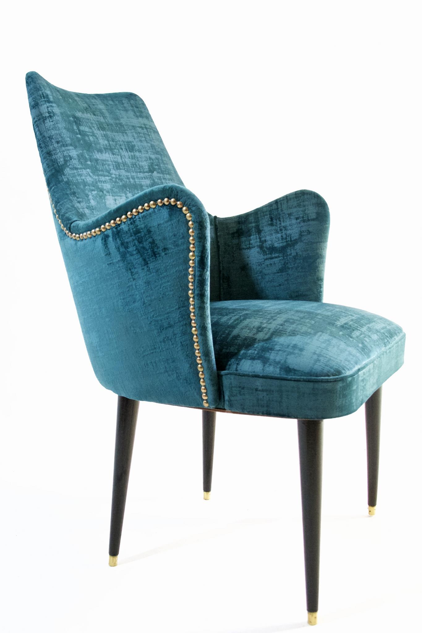 These chairs was designed by Osvaldo Borsani in the 1950s has been professionally restored and reupholstered. The fabric used is a high quality strong teal colored velvet that is easy to remove stains from. They have stained and lacquered wood legs