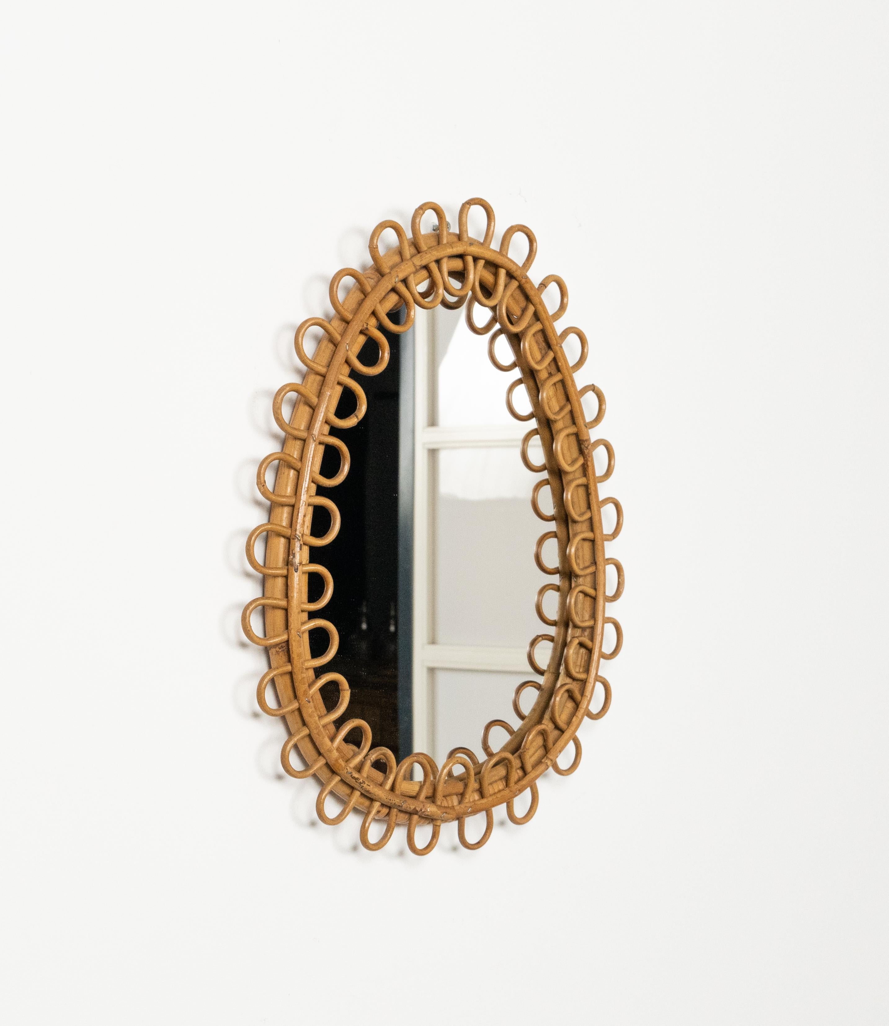 Midcentury amazing teardrop shape wall mirror in the style of Franco Albini.

Made in Italy in the 1960s.

This mirror has a rare teardrop form with delightful rattan figure-8 shapes framing the glass.
