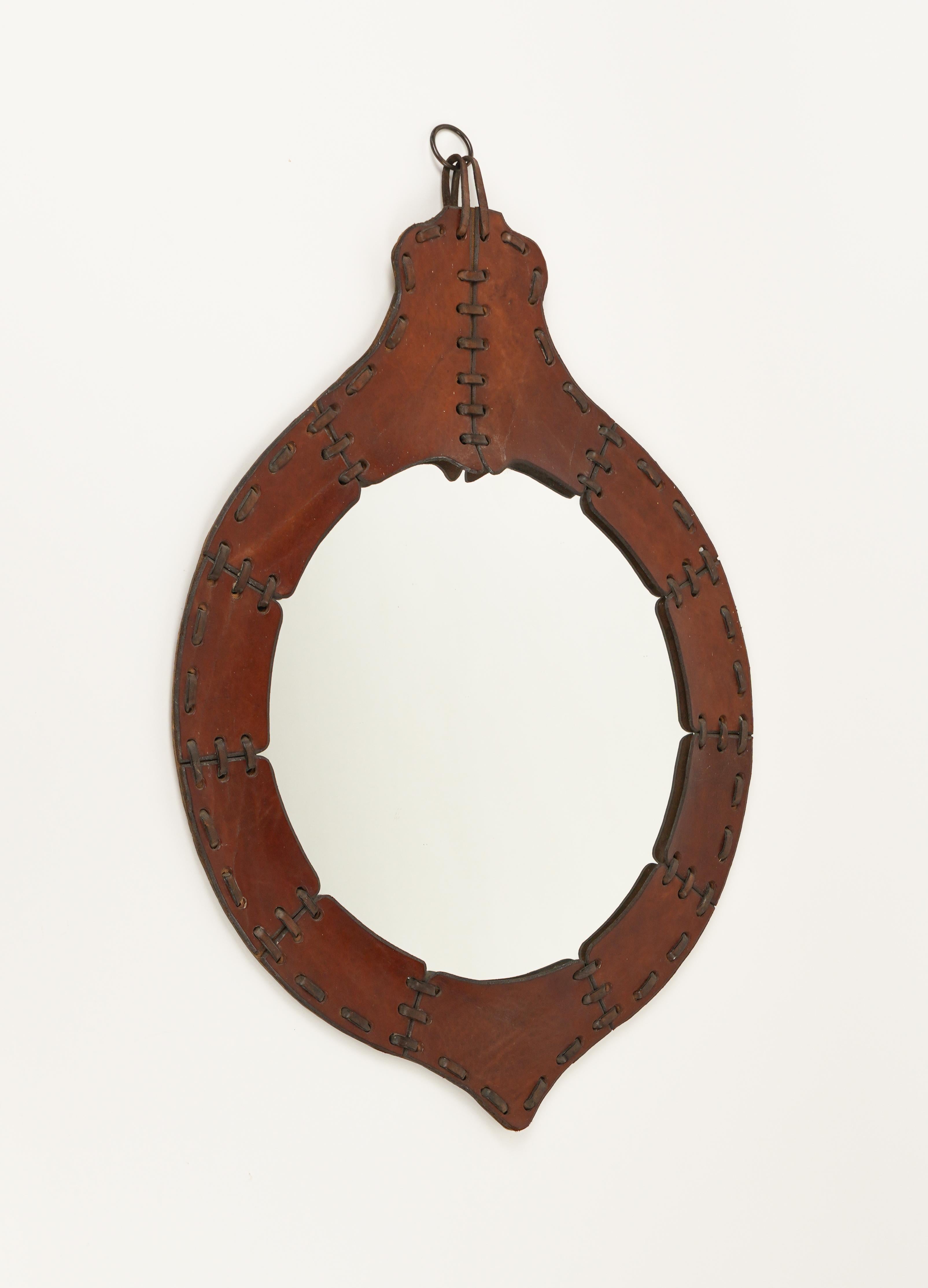 Midcentury amazing teardrop wall mirror in brown leather.

Made in Italy in the 1960s.