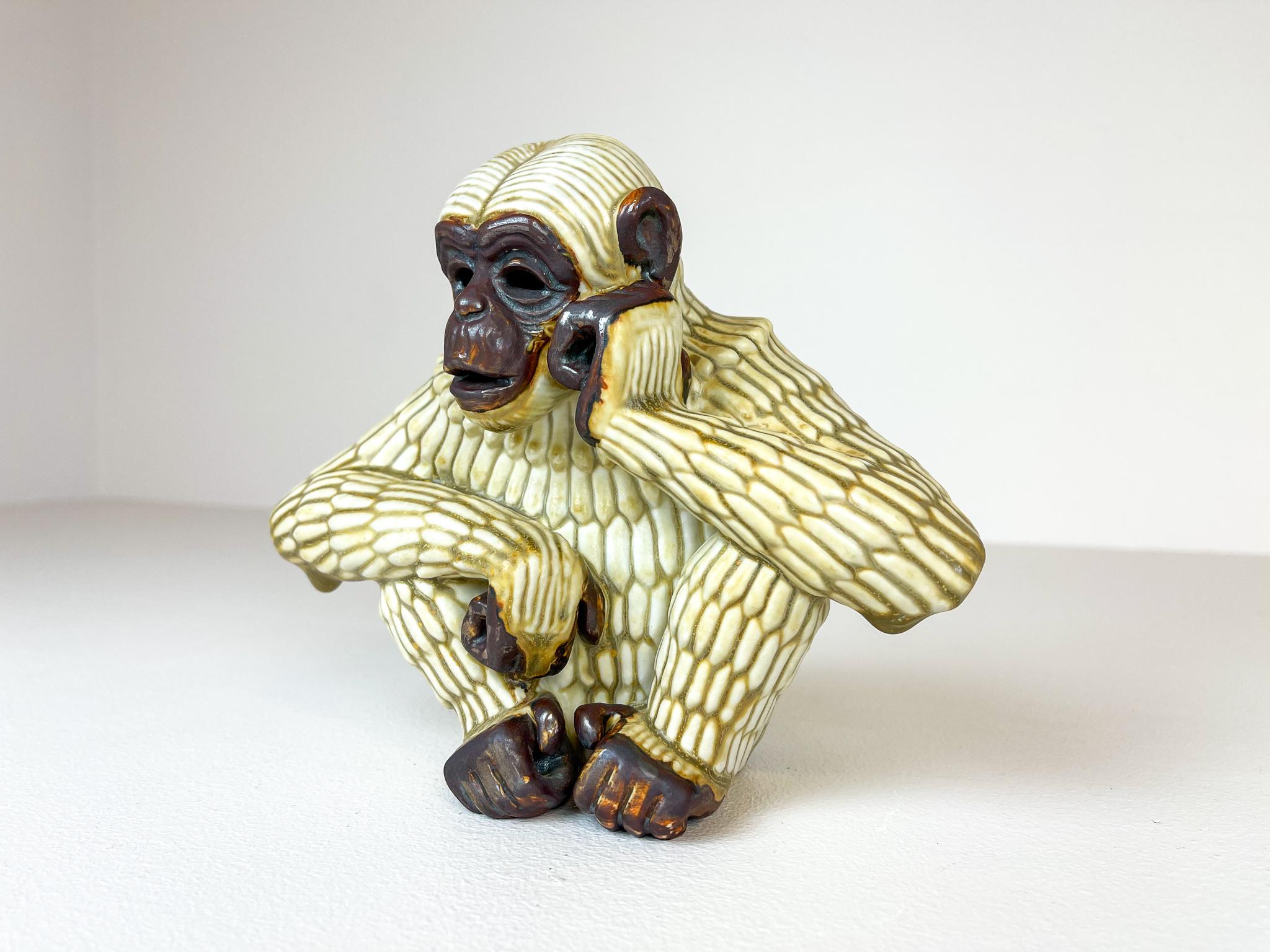 Fantastic sculpture of an ape with a lot on his mind, captured in great forms. Produced by Rörstrand and maker/designer Gunnar Nylund. Made in Sweden in the midcentury. Beautiful glazed and in good condition. Can be on or of its wooden