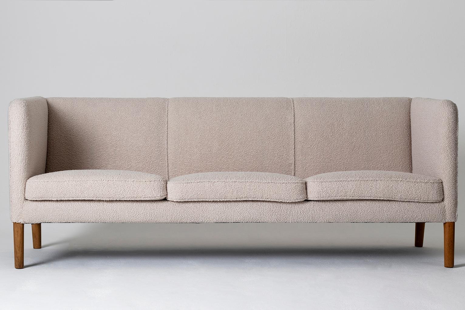 A three-seat sofa by Hans J. Wegner, (1914-2007).
Newly reupholstered in beige wool, on solid oak legs.
Manufactured by AP Stolen, model AP-18S.
Denmark, 1950s.
