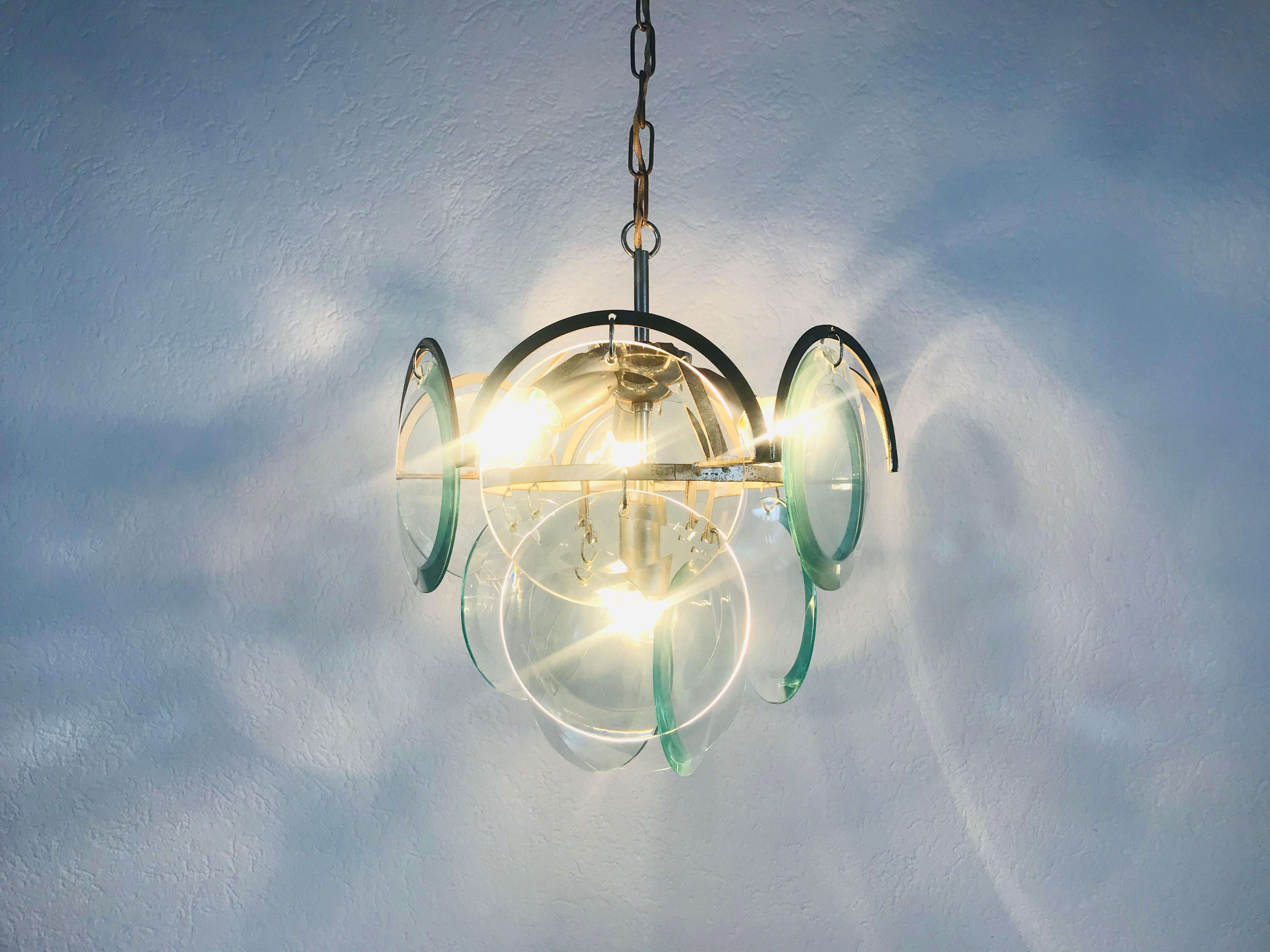 A midcentury chandelier made in Italy in the 1960s. It is fascinating with its colorful glasses and chrome body.

The light requires E14 light bulbs.