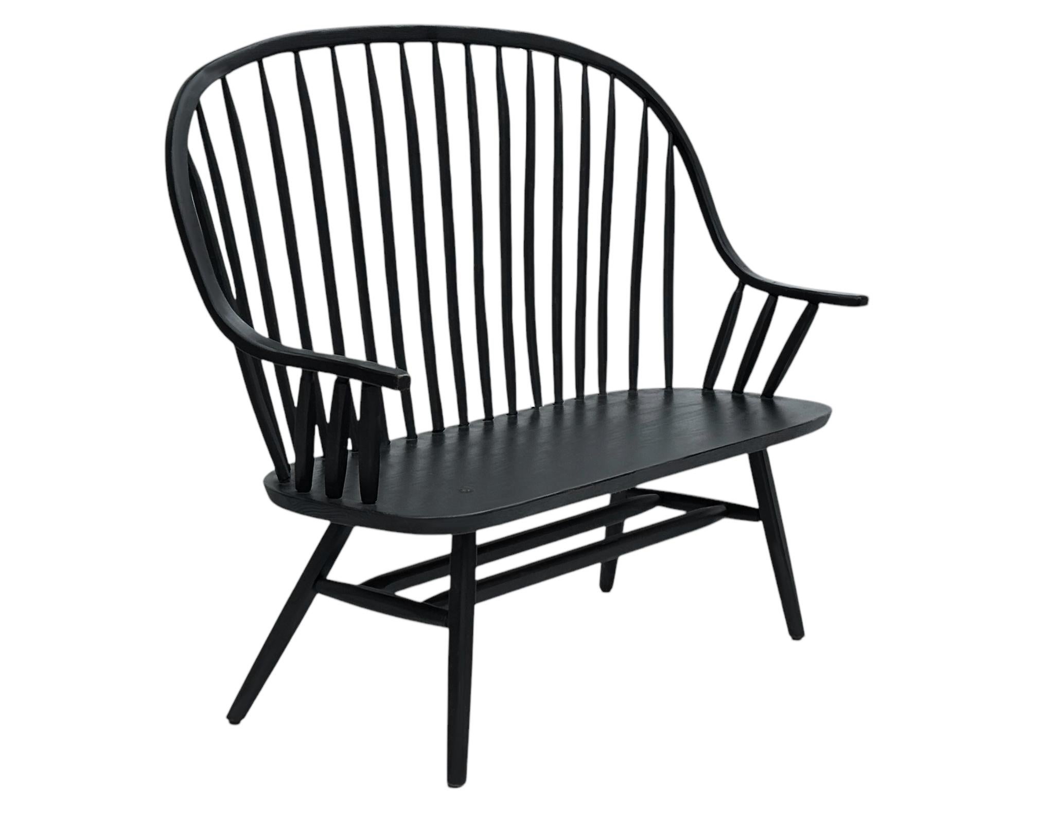 Un banc à dossier fuseau à la fois moderne et traditionnel des années 1960. Elle est très bien fabriquée en bois massif et finie en laque noire satinée. 