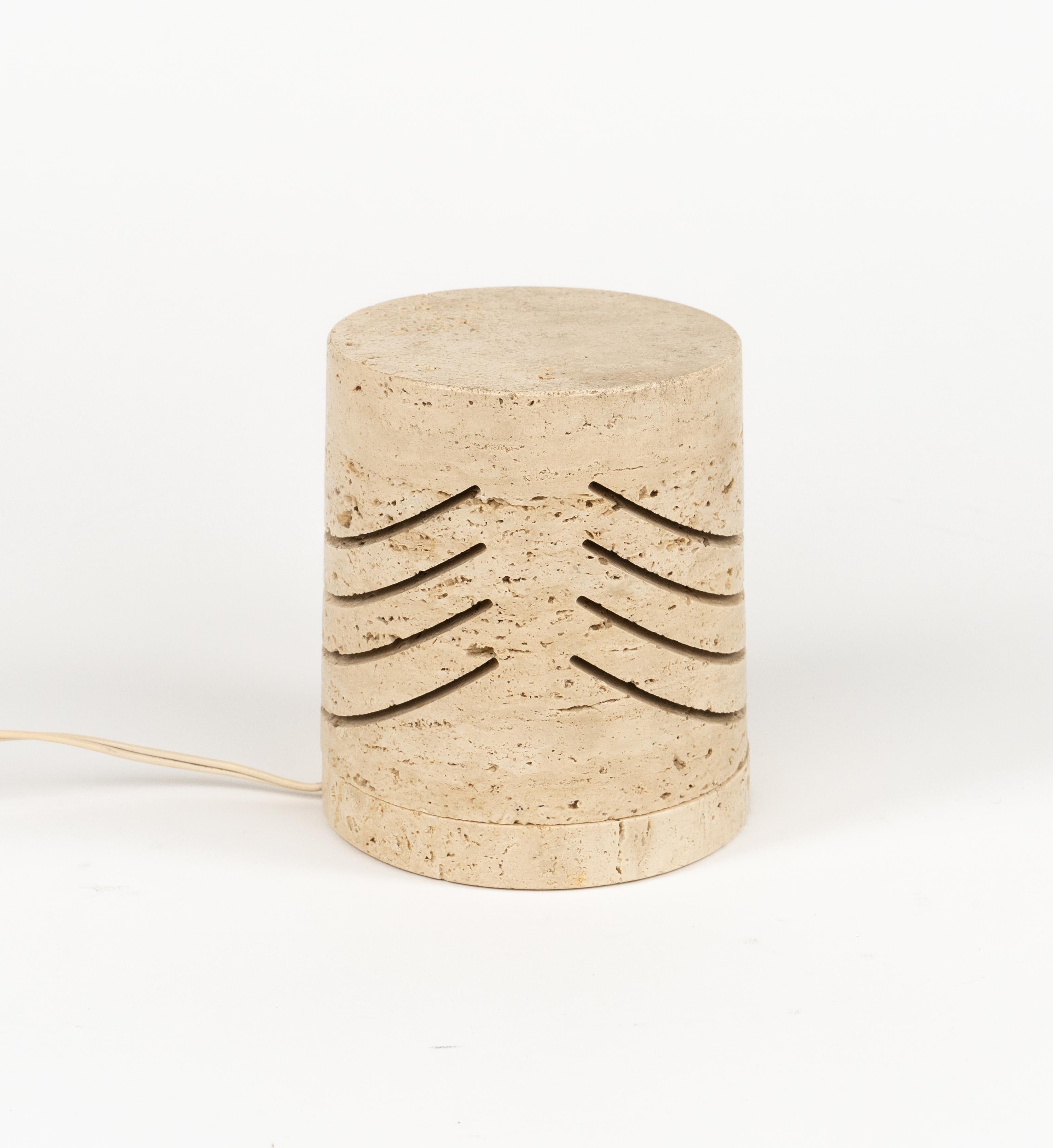 Midcentury amazing   travertine marble table lamp by Giuliano Cesari manufactured for Nucleo Sormani.

Made in Italy in the 1970s.

Compact travertine piece with minimal lighting cuts, emphasizing the stone texture.

European plug (works outside EU