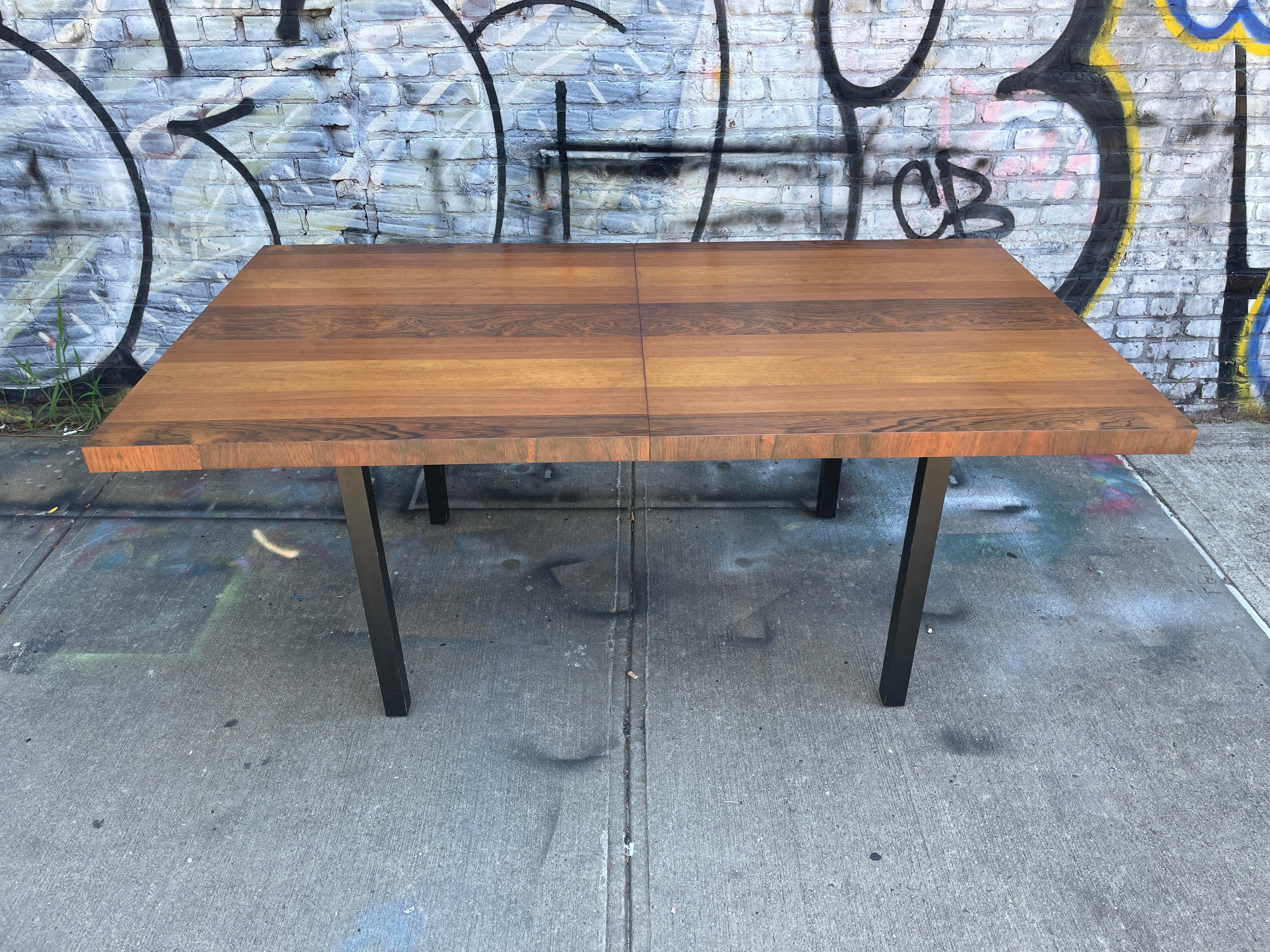 Mesa de comedor de estilo danés americano moderno de mediados de siglo, de Milo Baughman. Preciosa mesa de chapa de madera trilaminada fabricada en EE.UU. Increíble mesa de teca, palisandro y nogal. Fabricada hacia 1960 con patas de madera maciza