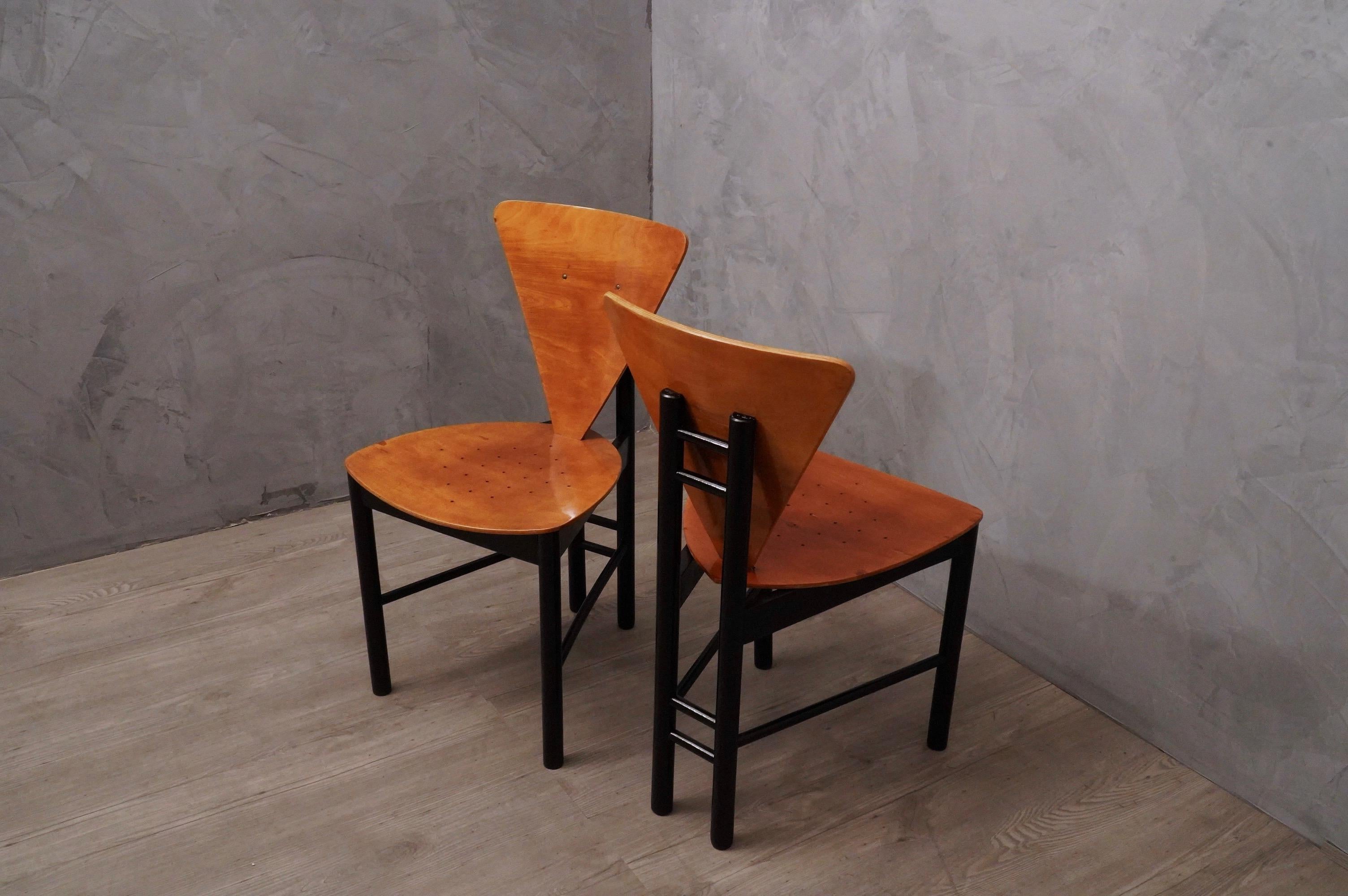 Paire de chaises latérales au style très rigide et au design surprenant, dans le style italien caractéristique de cette période.

La paire de chaises a une structure en bois de hêtre laqué avec de la gomme-laque noire, tandis que l'assise et le