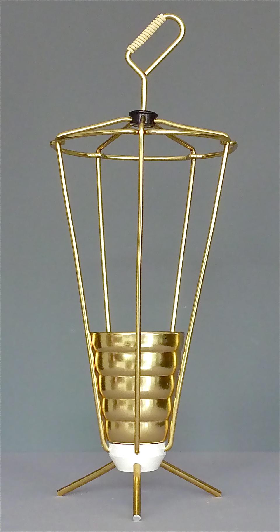 Schöner italienischer goldener Dreibeinschirmständer aus den 1950er Jahren. Schirmständer aus goldfarben eloxiertem Aluminium mit weiß emailliertem, beschwertem Sputnik-Sockel, einem goldenen Becher als Regentropfenfänger und weißer
