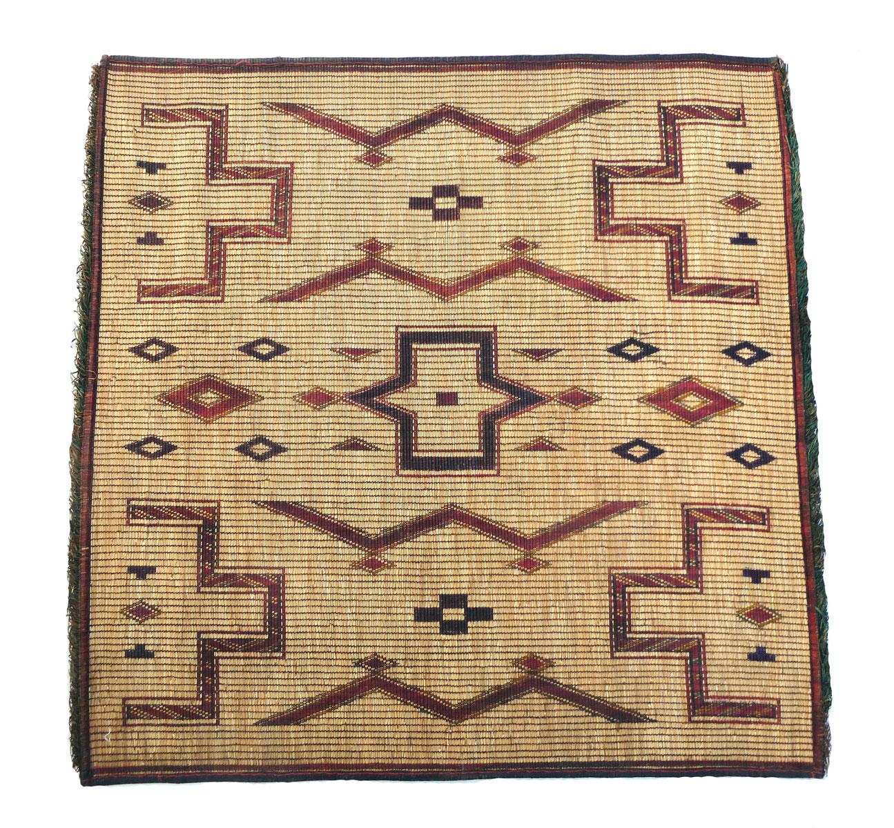 Stuoia Tuareg vintage intrecciata a mano con canne di palma e pelle marrone scuro e sangue di bue con un disegno tribale con simboli berberi.
Dimensioni: 3'9 X 3'10