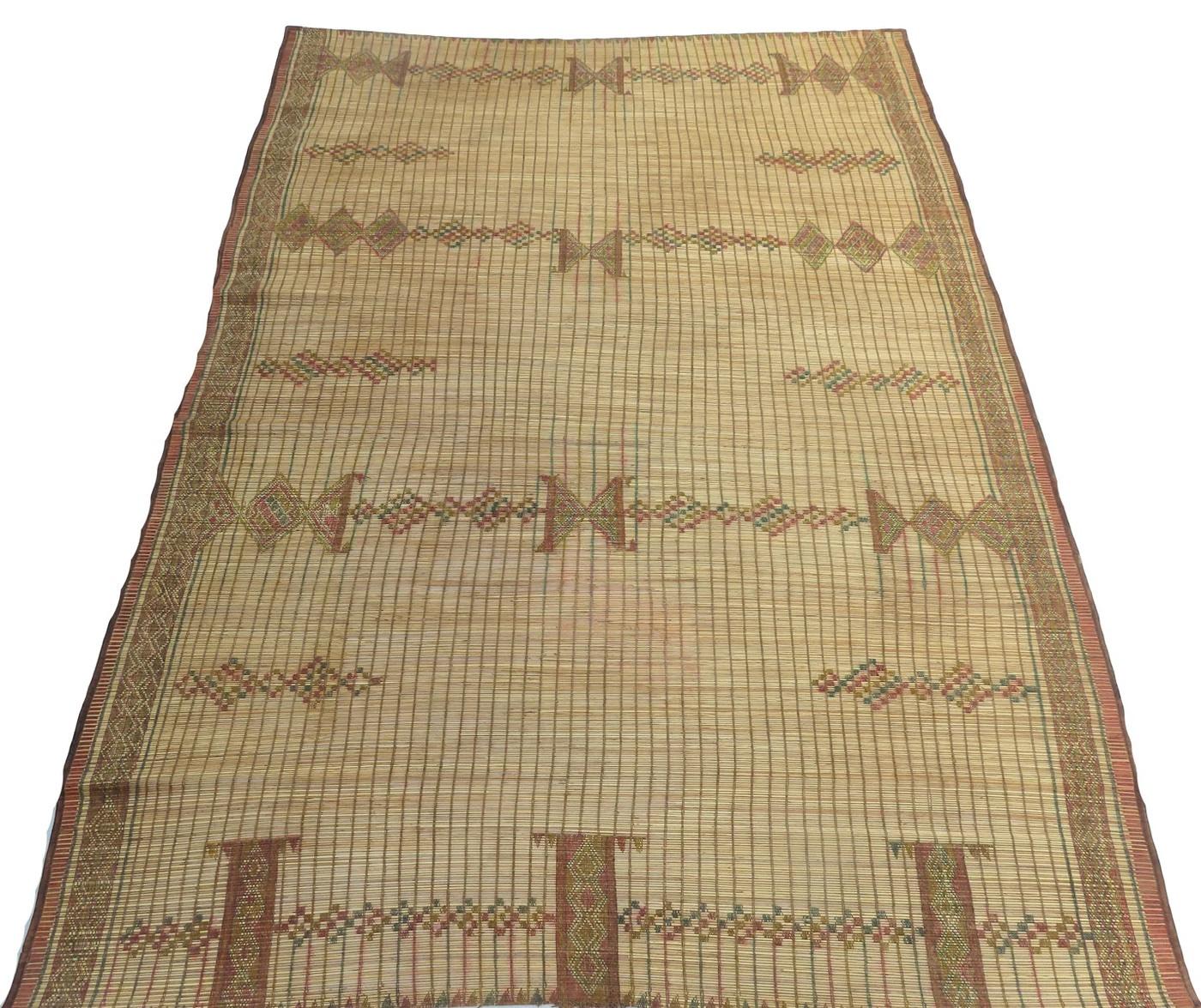 Stuoia Tuareg vintage intrecciata a mano con canne di palma e pelle in un disegno tribale con simboli berberi.
Dimensioni:  6'1 x 8'11