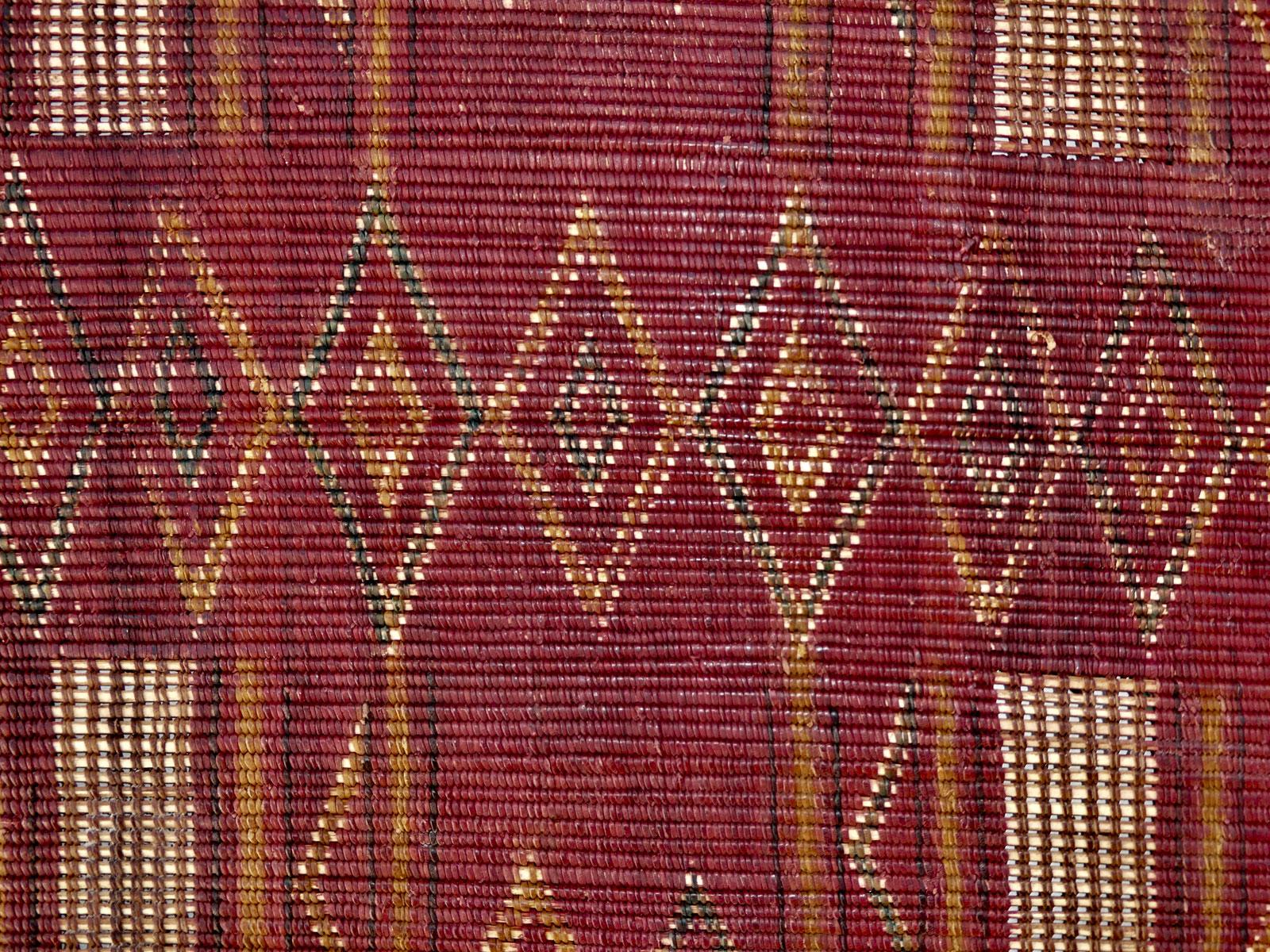 Natte touareg des années 1960 tissée à la main avec du roseau et du cuir dans un motif tribal avec des symboles berbères et de superbes franges vertes. État exceptionnel.
Dimensions : 3'3 x 4'3