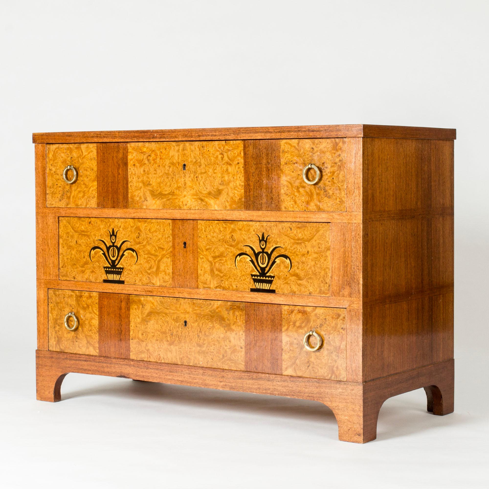 Beautiful chest of drawers by Carl Malmsten, model called “Tulipanros” (“Tulip Rose”), made in mahogany and root veneer laid in an elegant pattern. Graphic decor on the drawer fronts of flowers in planters.