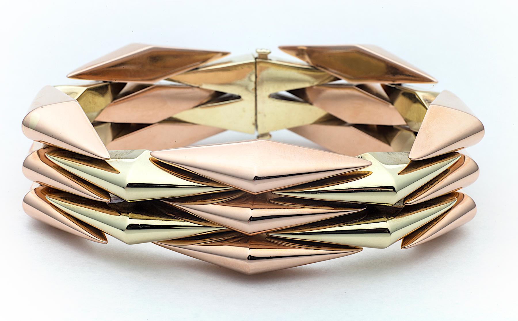 Looking sleekly architectural and crisply modern, this mid-century machine age bracelet, circa 1945, has a fresh design that is one-of-a-kind.  With connecting and moveable triangular links of alternating 14 karat rose and yellow gold, it is a