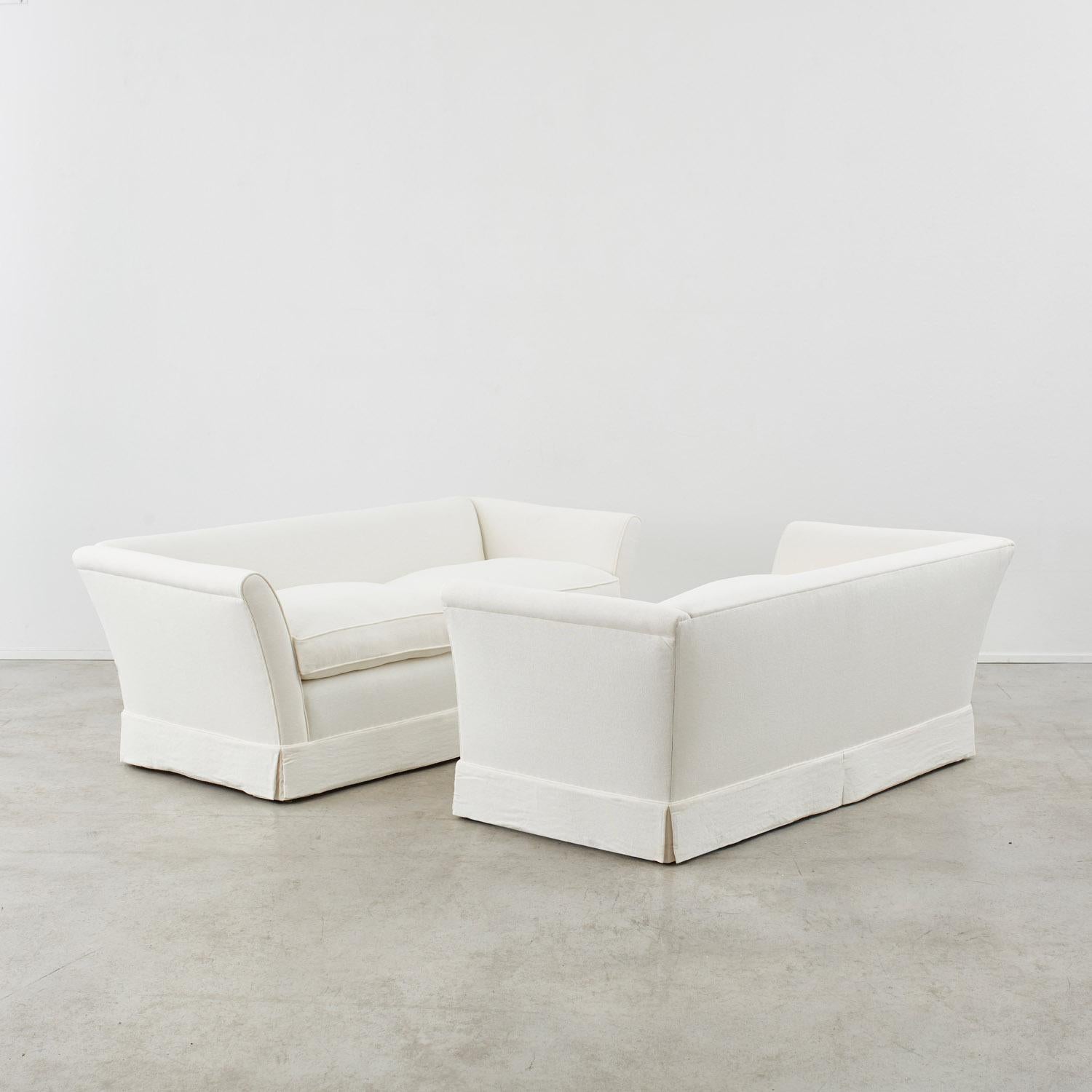Carefully tailored, this pair of midcentury sofas embody the restrained elegance of Scandinavian modernism. Designed for Nordiska Kompaniet in the mid-20th century, the pieces’ rational form creates a striking, clean silhouette. Combining arms that