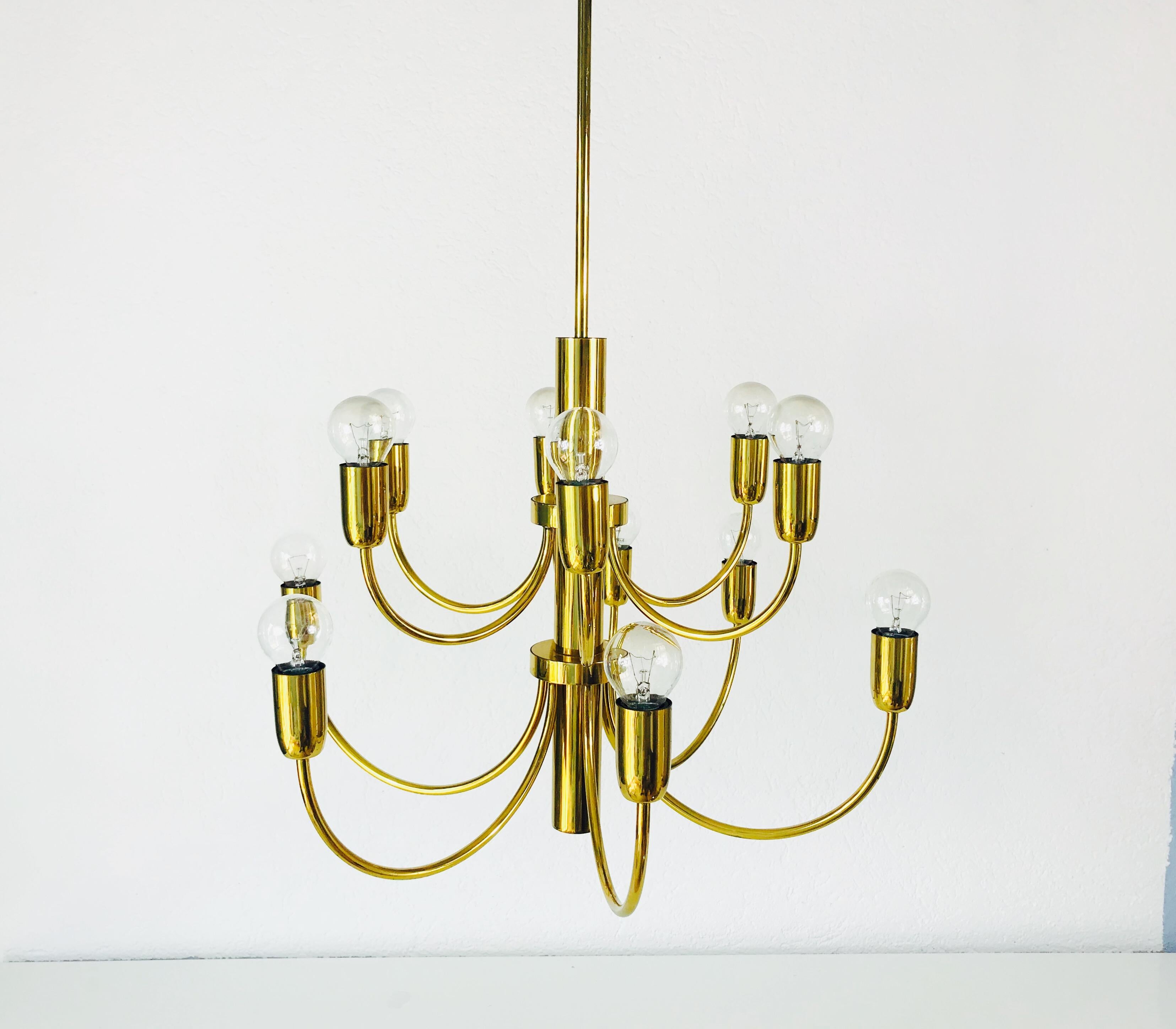 A midcentury chandelier made in Germany in the 1960s. It is fascinating with its twelve brass arms, each of it with an E14 light bulb. The body is also made of full brass. The shape of the light is similar to a spider.

The light requires twelve