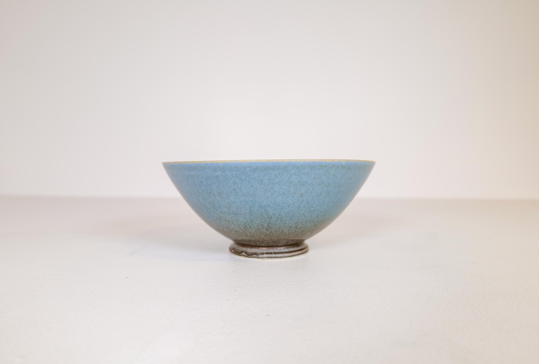 This bowl was handmade and glazed in the G-studio factory at Gustavsberg by Sven Wejsfelt. At the K-studio designers was given the spirit to produce unique art for Gustavsberg. 
The bowl is perfectly shaped and has a wonderful green /blue