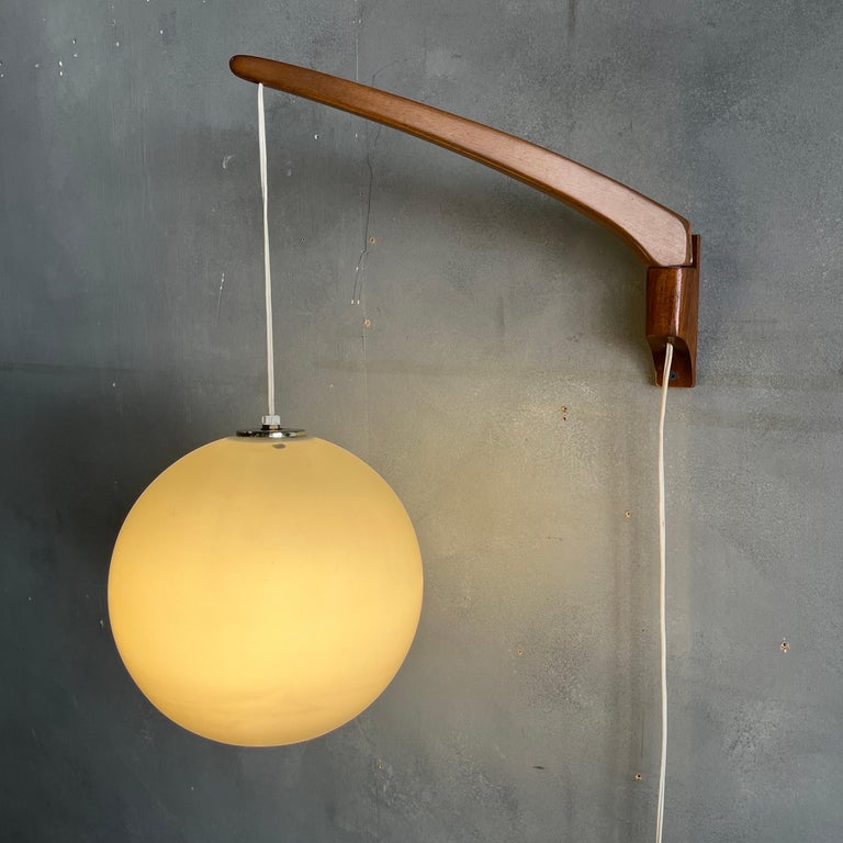 Beautiful Adjustable swing arm wall lamp by Luxus od Sweden. Frosted glass sphere measures 9'' across. Can be adjusted vertically and swing arm 180' by 15''. No apparent chips to glass. Wonderful original vintage condition.