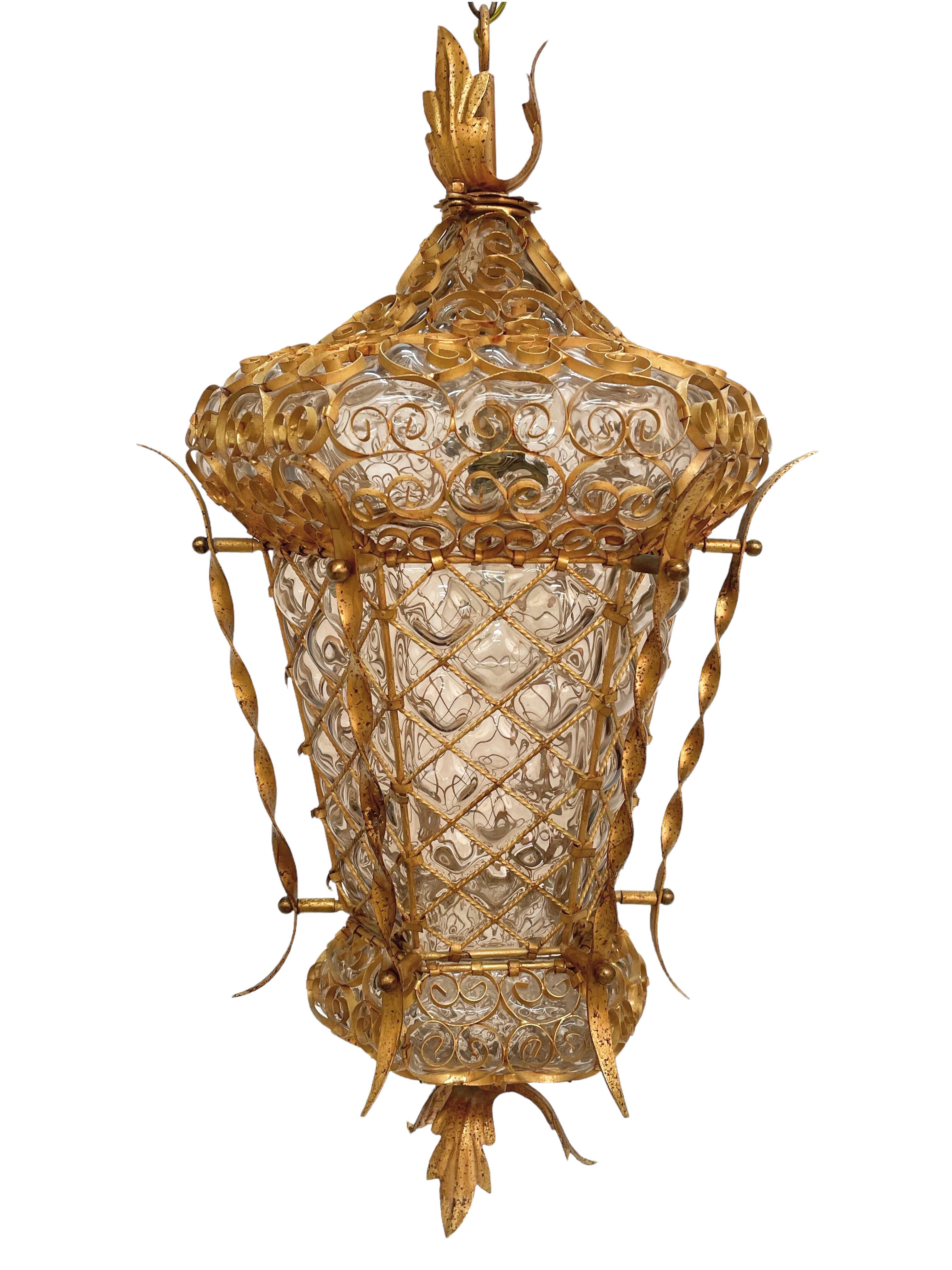 Incredible Venetian lantern in blown glass perfectly and symmetrically in the golden wrought iron structure.
This exceptional piece was designed in Italy in the 1940s.

This chandelier is incredible for the accuracy in the decoration of the iron