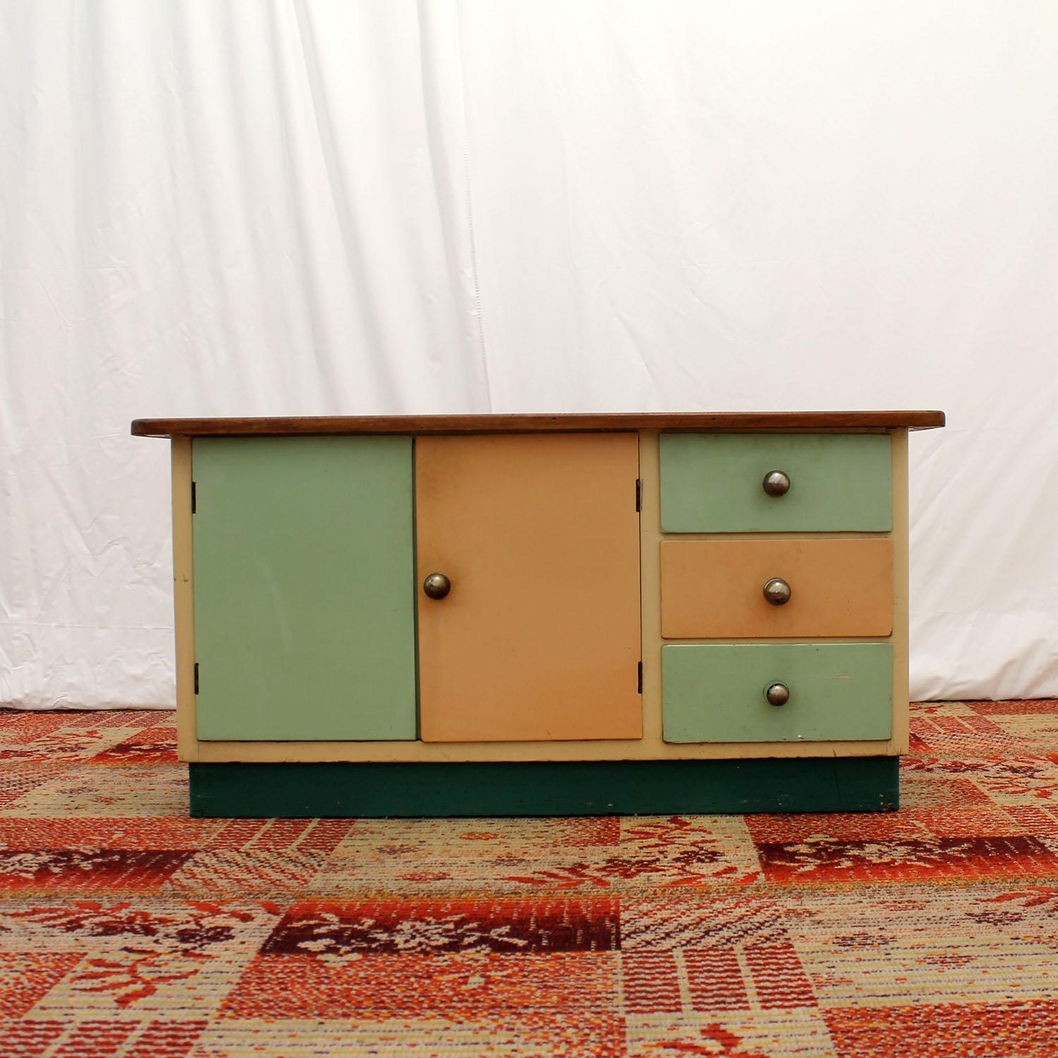 Midcentury chest of drawers, it was made in Czechoslovakia in the 1950s. Made of solid wood, it has chrome handles, laminate surface on the top, colored lacquered doors. The cabinet is in good preserved Vintage condition with nice patina, showing