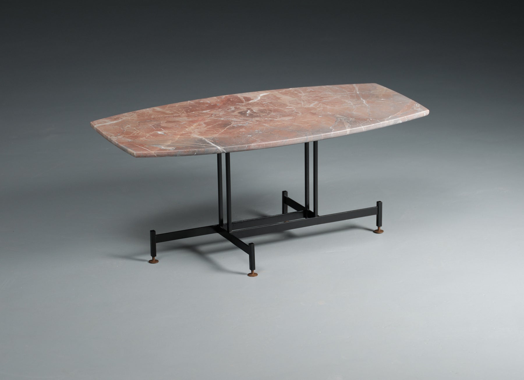 This midcentury vintage coffee table is a true testament to timeless design. Its standout feature is the thick marble tabletop, showcasing various shades of reddish-gray with elegant white veining. The marble exudes a unique character that adds a