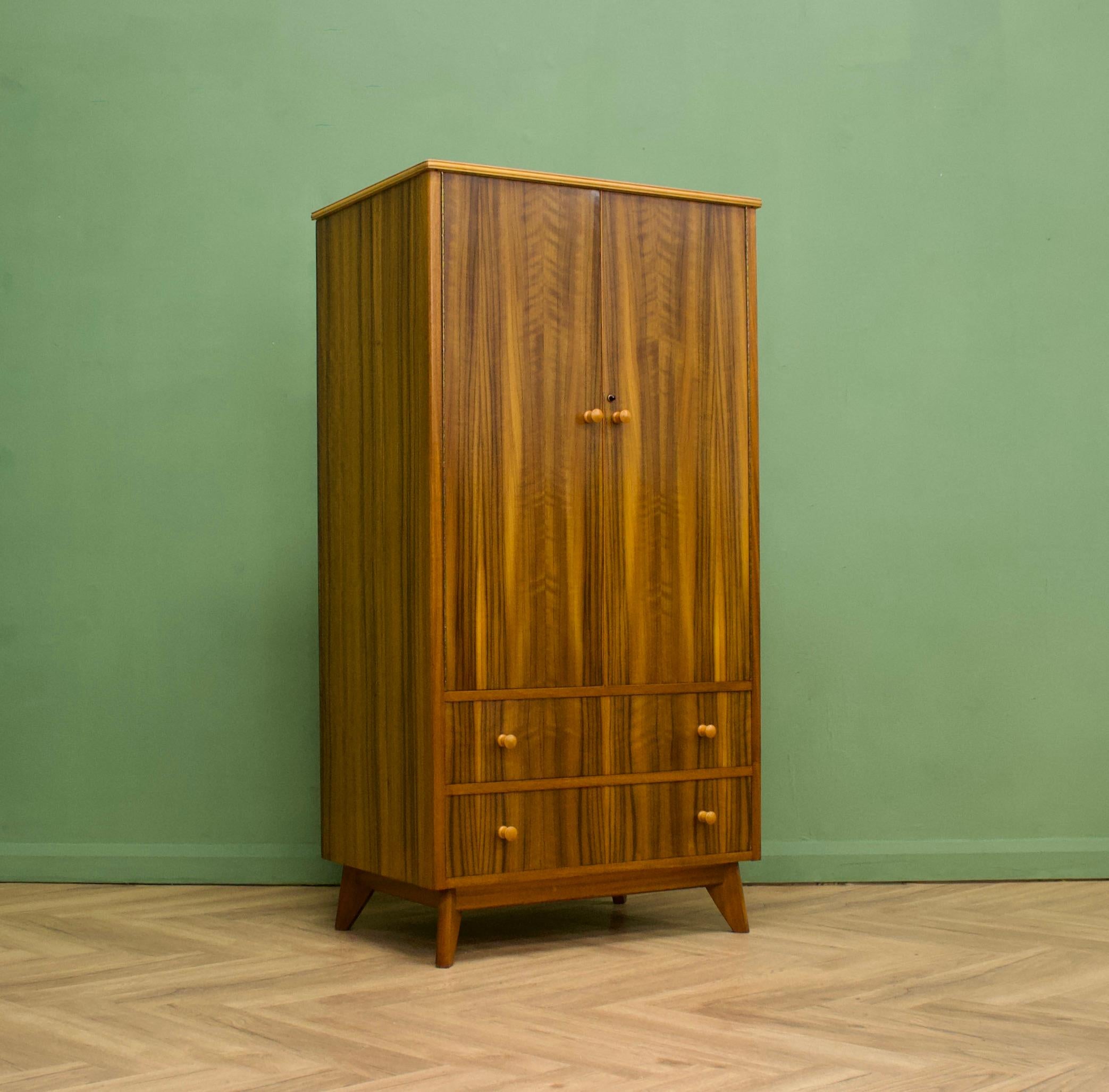 A walnut freestanding wardrobe by Morris of Glasgow - circa 1950s

Internally there is a hanging rail and to the bottom are two drawers- a lot of storage for such a compact wardrobe
The attractive legs are slightly tapered and the handles are solid