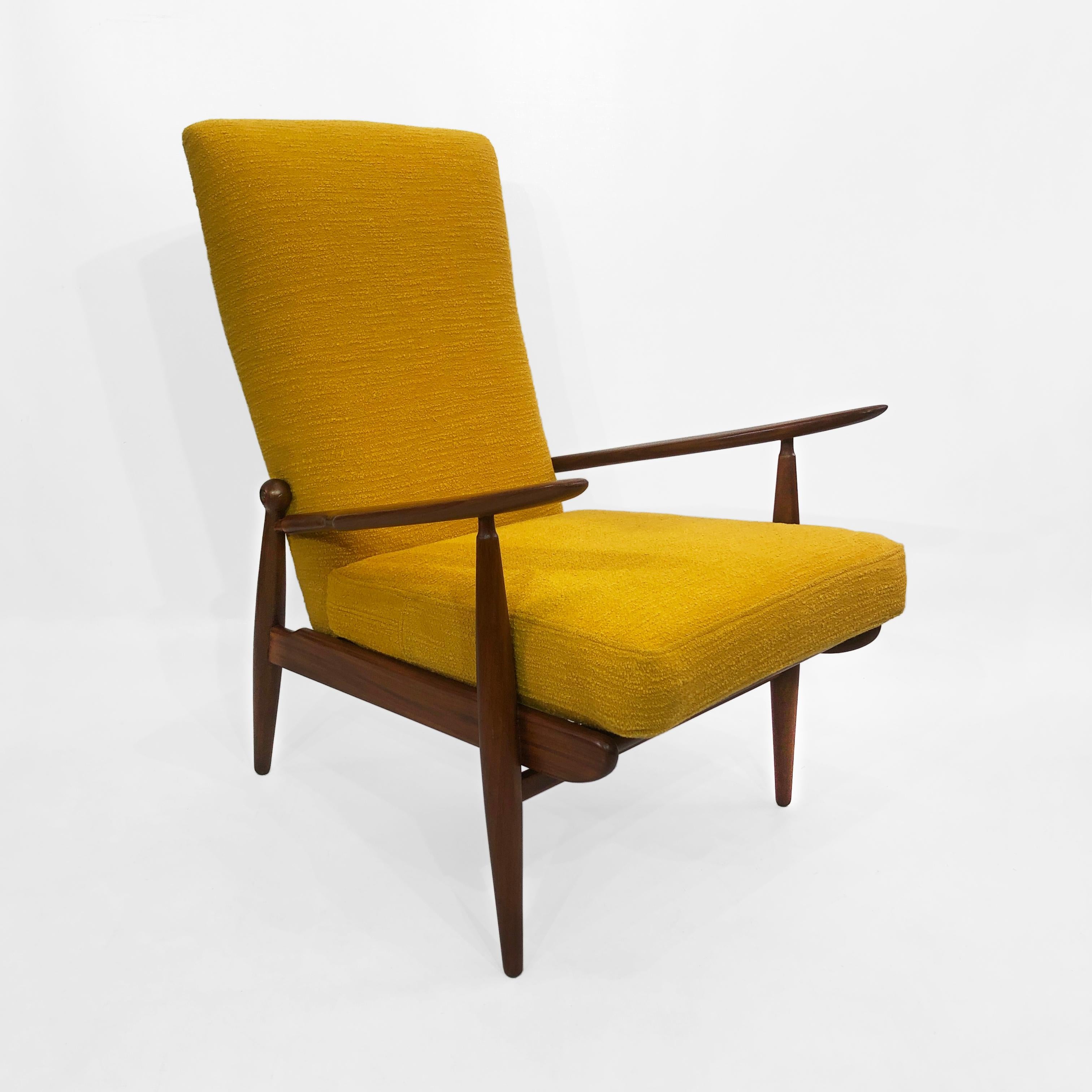 This high-backed Danish style yellow bouclé armchair, is a wonderful example of midcentury European design. The aerodynamic design and curves on the wood frame makes it an easy addition to any room. 

A refinished walnut wood frame houses a foam