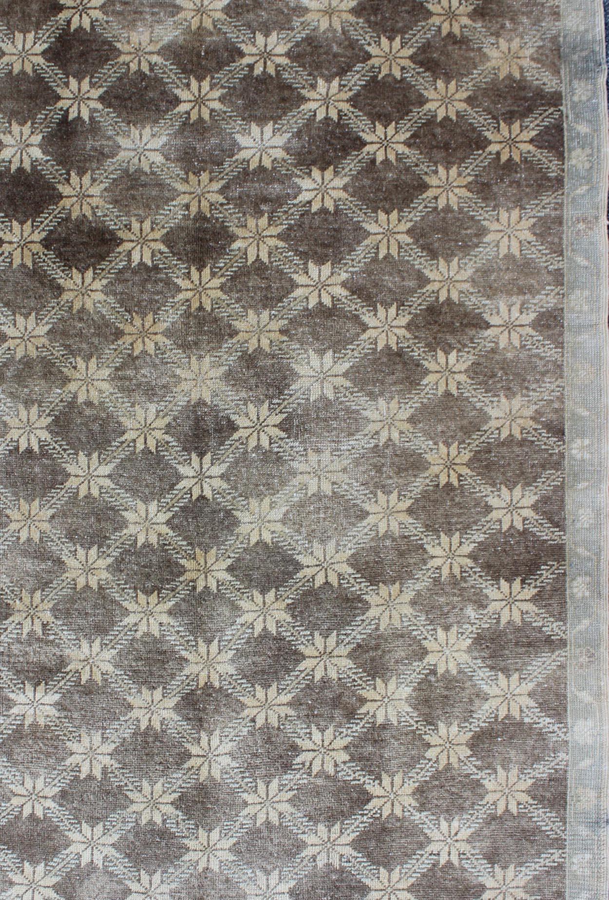 Measures: 5 x 7'10

The design of this beautiful vintage Oushak rug from mid-20th century Turkey. The brown background is home to an all-over cream lattice design decorated with flower motifs. A taupe border of flowers encompasses the entirety of