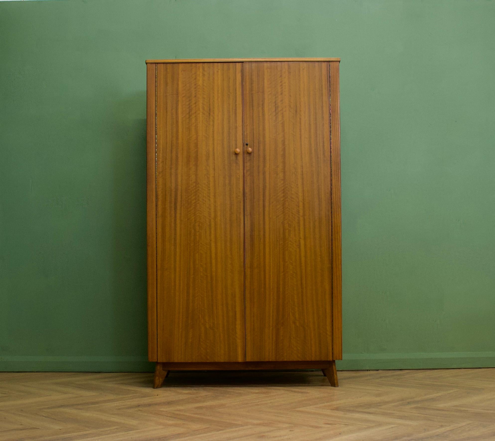 A walnut freestanding wardrobe by Morris of Glasgow - circa 1950s
Internally there is a rail and a shelves
The attractive legs are slightly tapered and splayed, complete with a working push to open latch