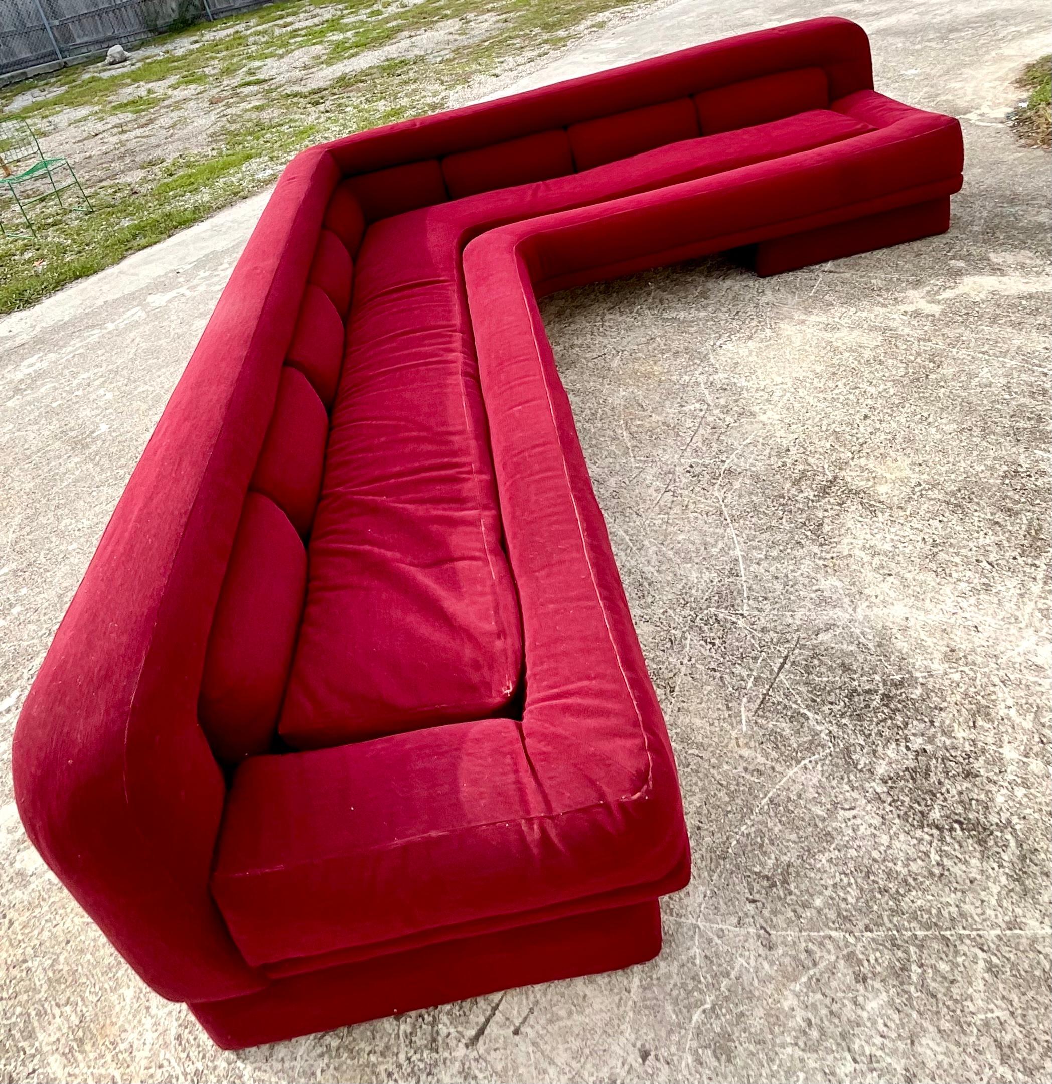 Incredible vintage midcentury L shaped sofa. Beautiful wine colored boucle with a one piece inset cushion. Lucite blade on the bottom corner. Acquired from a Palm Beach estate.