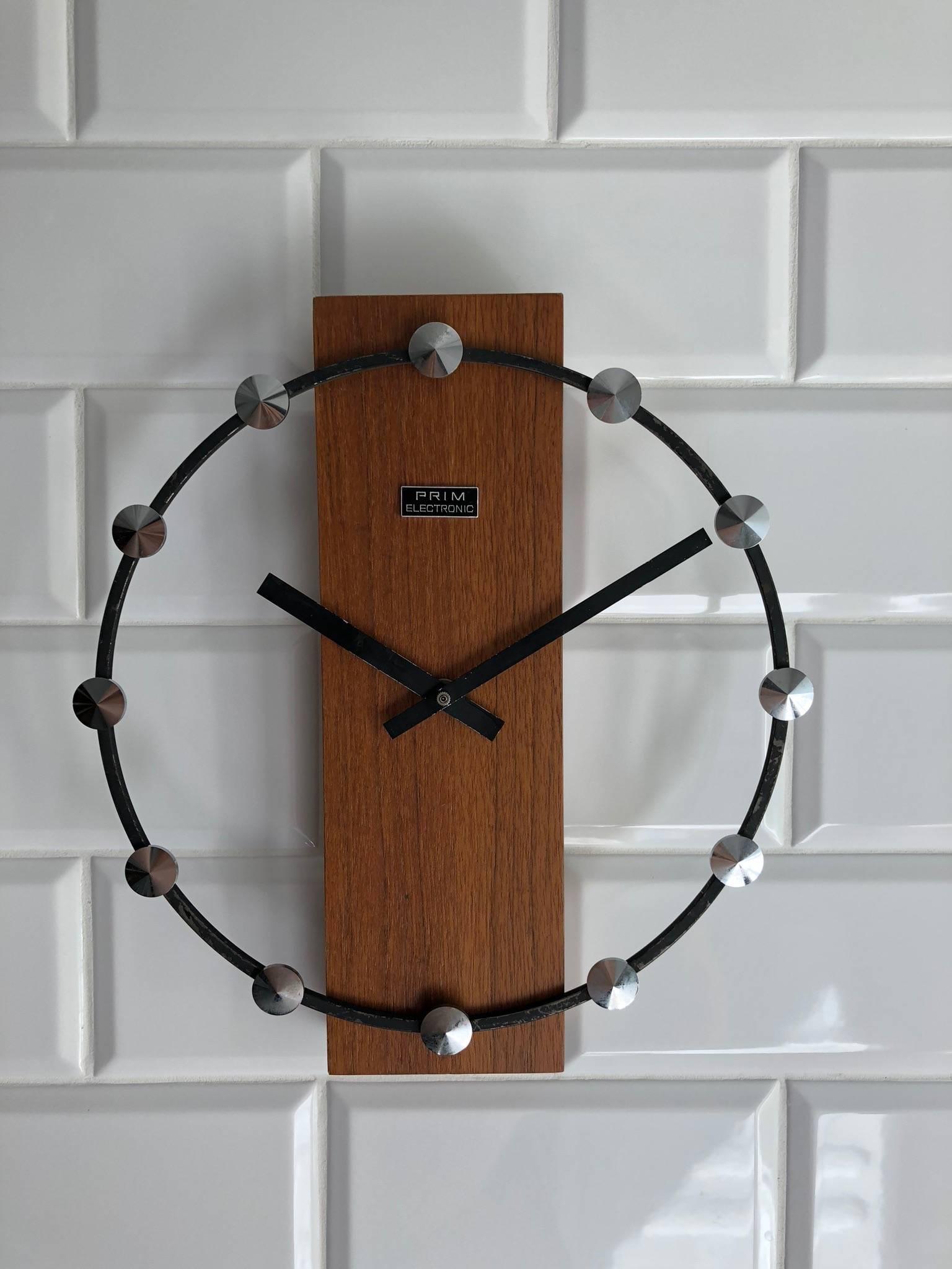 Wooden frame with a steel ring and aluminum pointer, fitted with a battery movement. Made by Prim Clocks in the late 1960s.