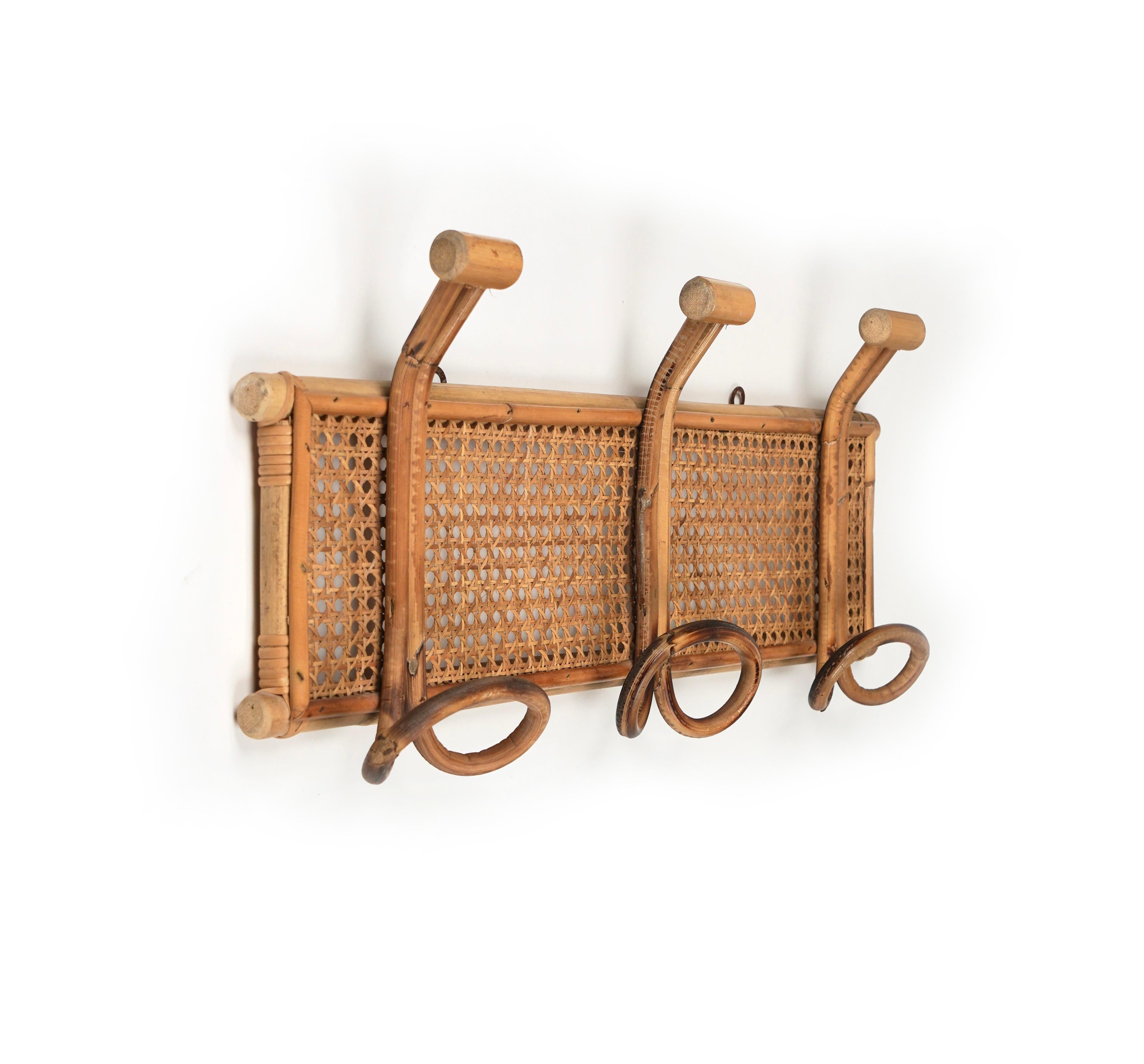 Midcentury coat rack stand in bamboo and rattan with three hooks. 

Made in Italy in the 1970s. 

The rattan material provides an easygoing chic, which flatters any interior.
