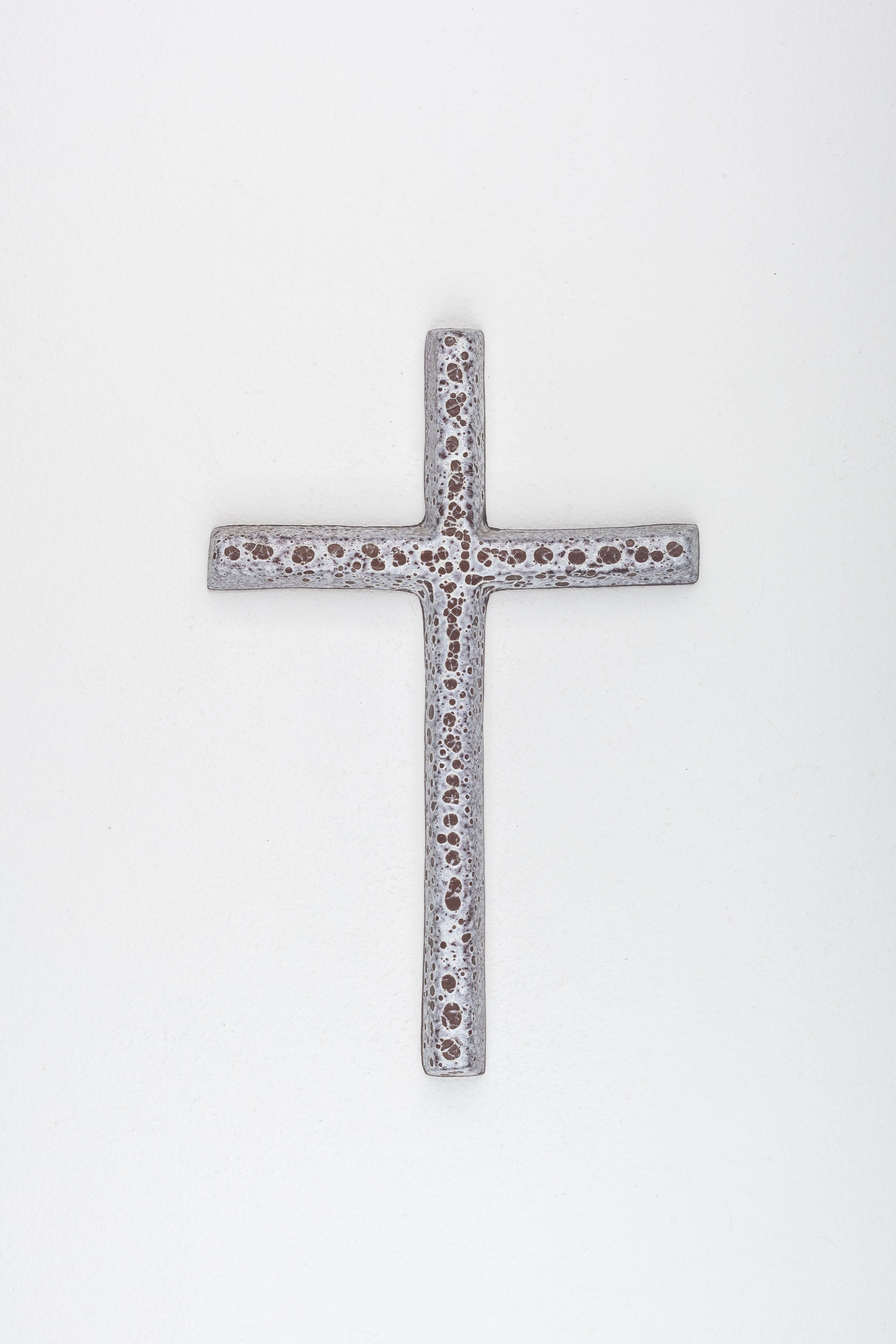 This mid-century wall cross embodies the distinctive European design ethos of the 1950s, masterfully handcrafted by a studio pottery artist. The piece features a 