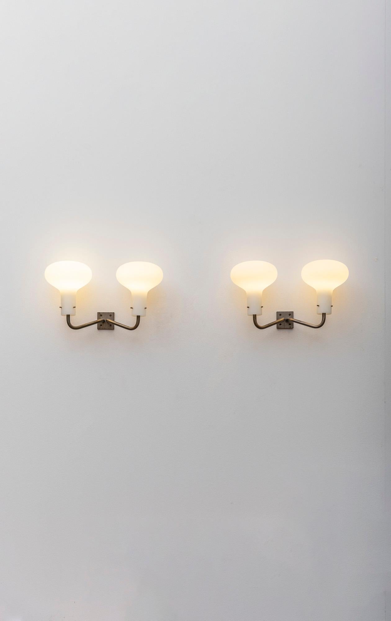 Iconic pair of LP12 wall lights by Ignazio Gardella for Azucena. 
Nickeled brass hardware with two large satin glass diffusers. 
Italy, 1960. 
Very good vintage condition.