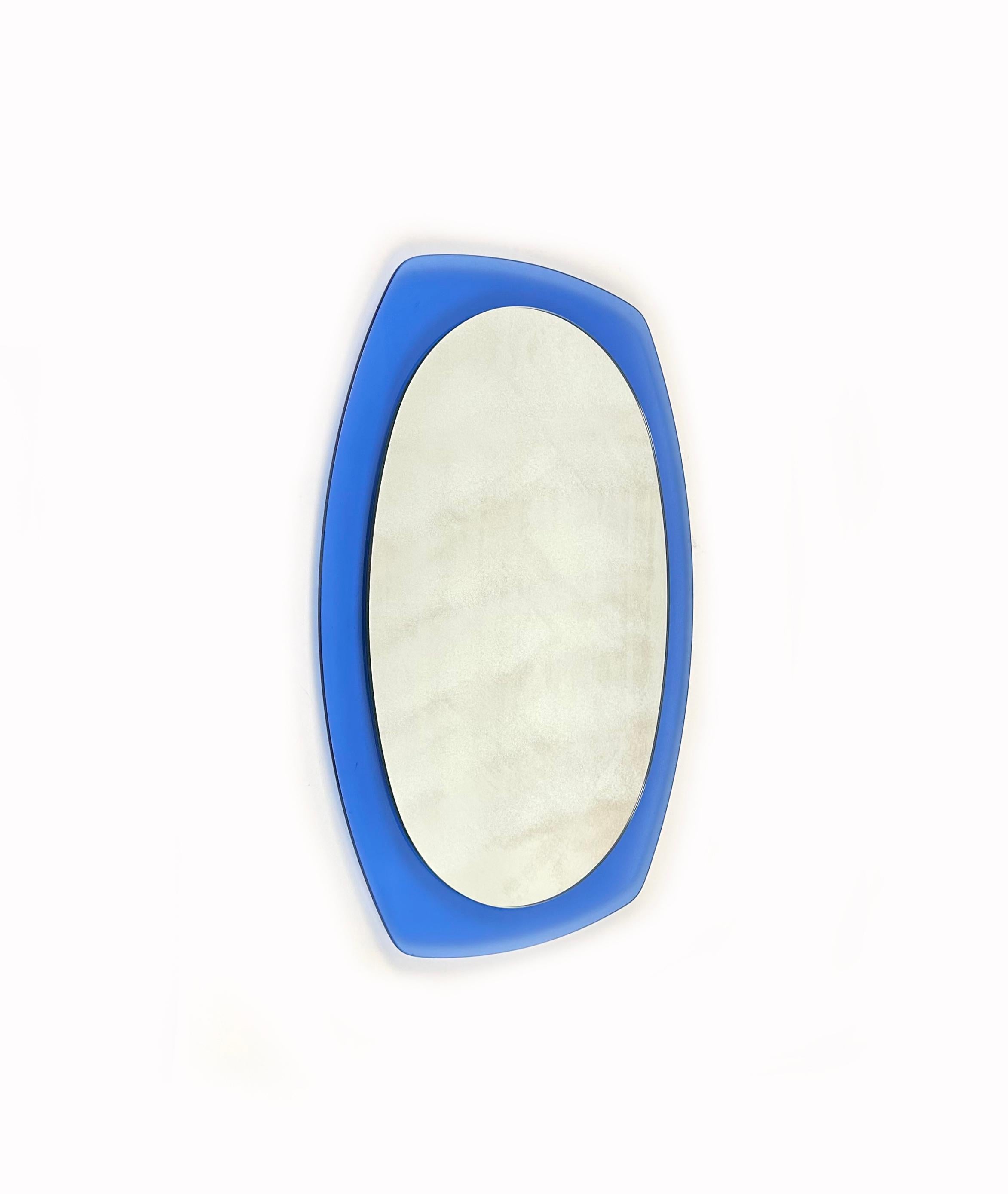Midcentury Italian mirror, beveled looking glass mounted onto a blue glass.

Made in Italy in the 1970s.

It comes with its original label signed 