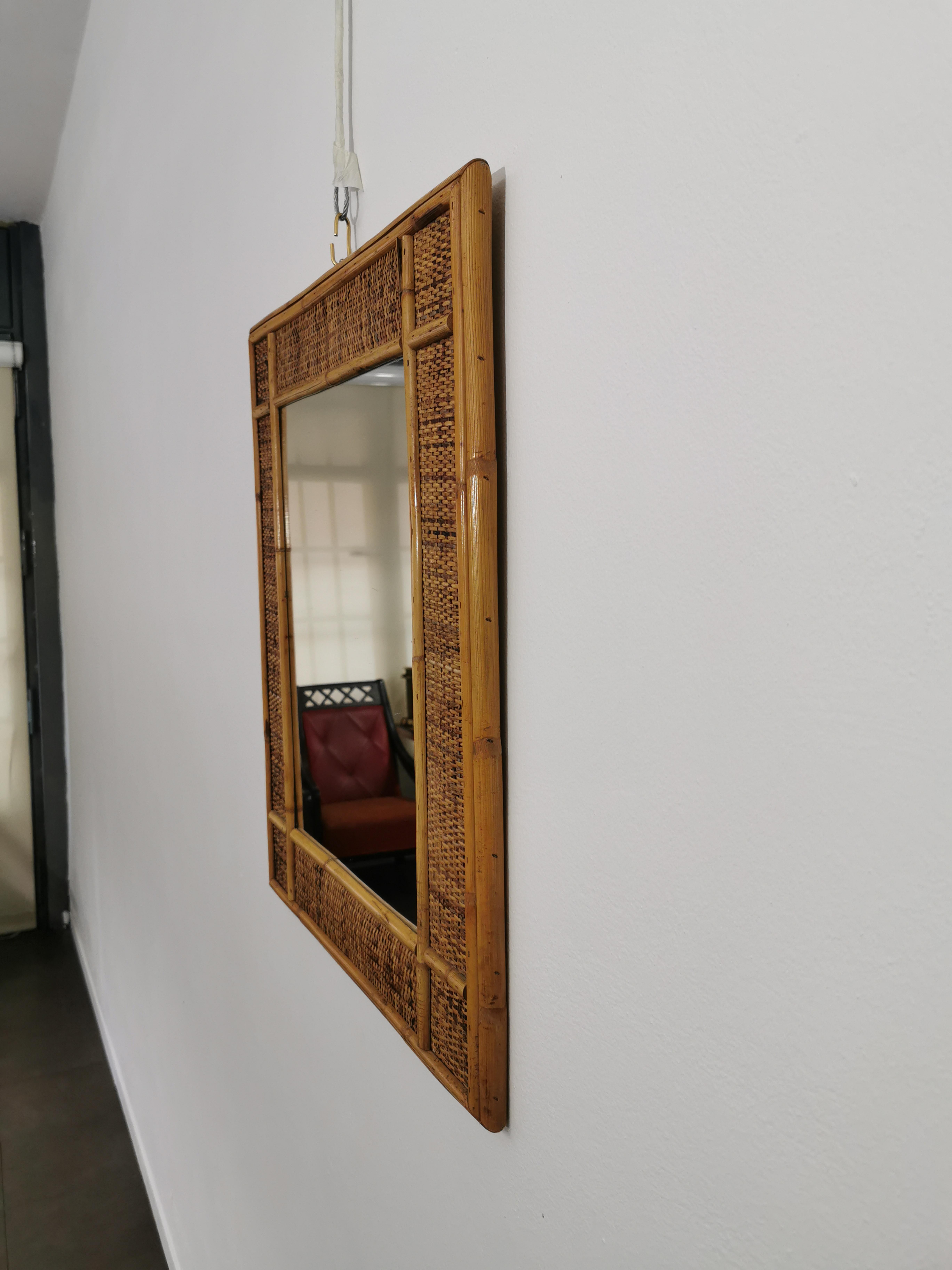 Rectangular wall mirror produced in Italy in the 1960s. The mirror was made of wicker and with a bamboo cane frame.