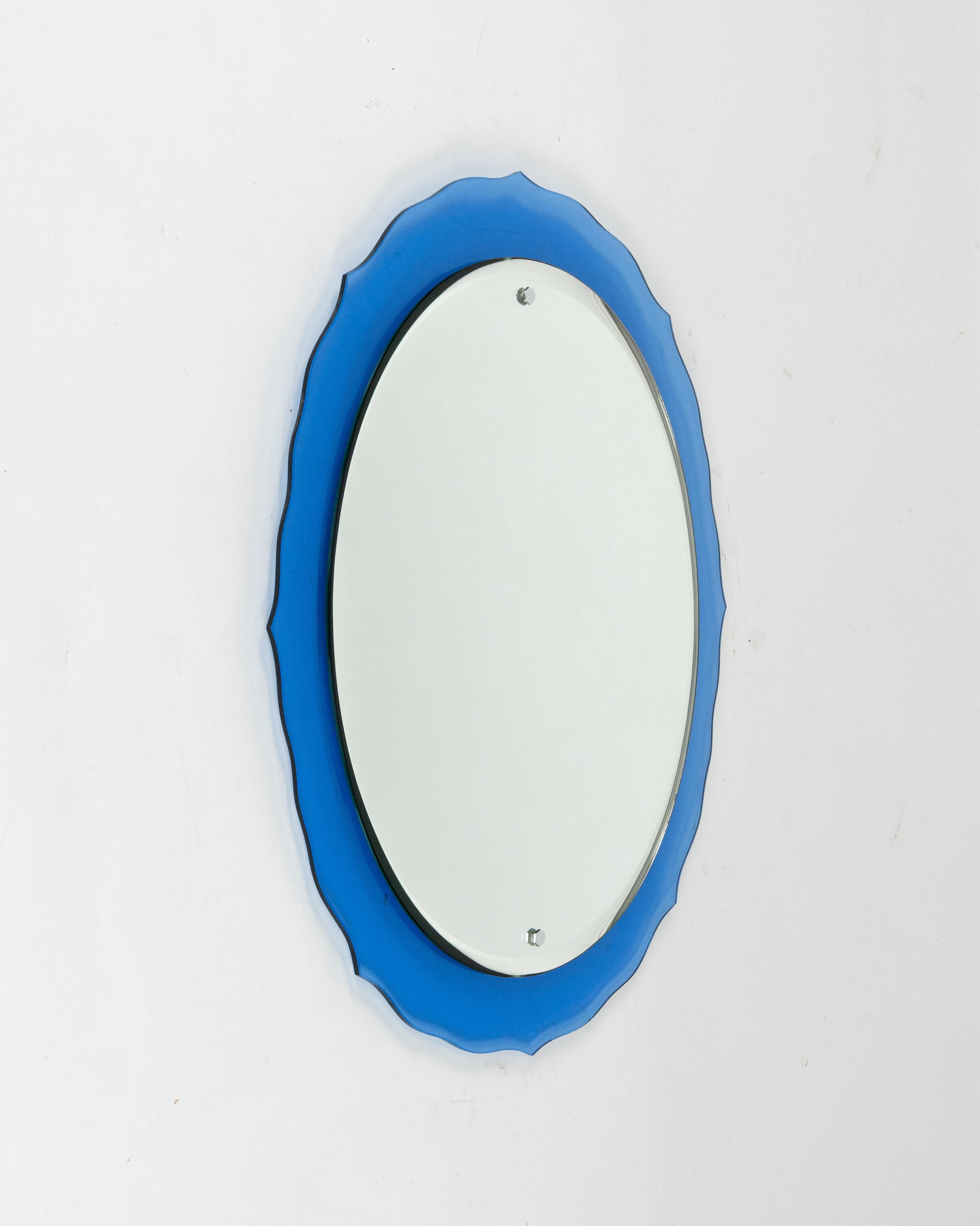 Erstaunlicher doppelstöckiger ovaler Wandspiegel mit blauem Glasrahmen aus der Mitte des Jahrhunderts, der Cristal Art zugeschrieben wird.  

Hergestellt in Italien in den 1960er Jahren.

Cristal Arte (gegründet 1944) war ein Möbelunternehmen, das